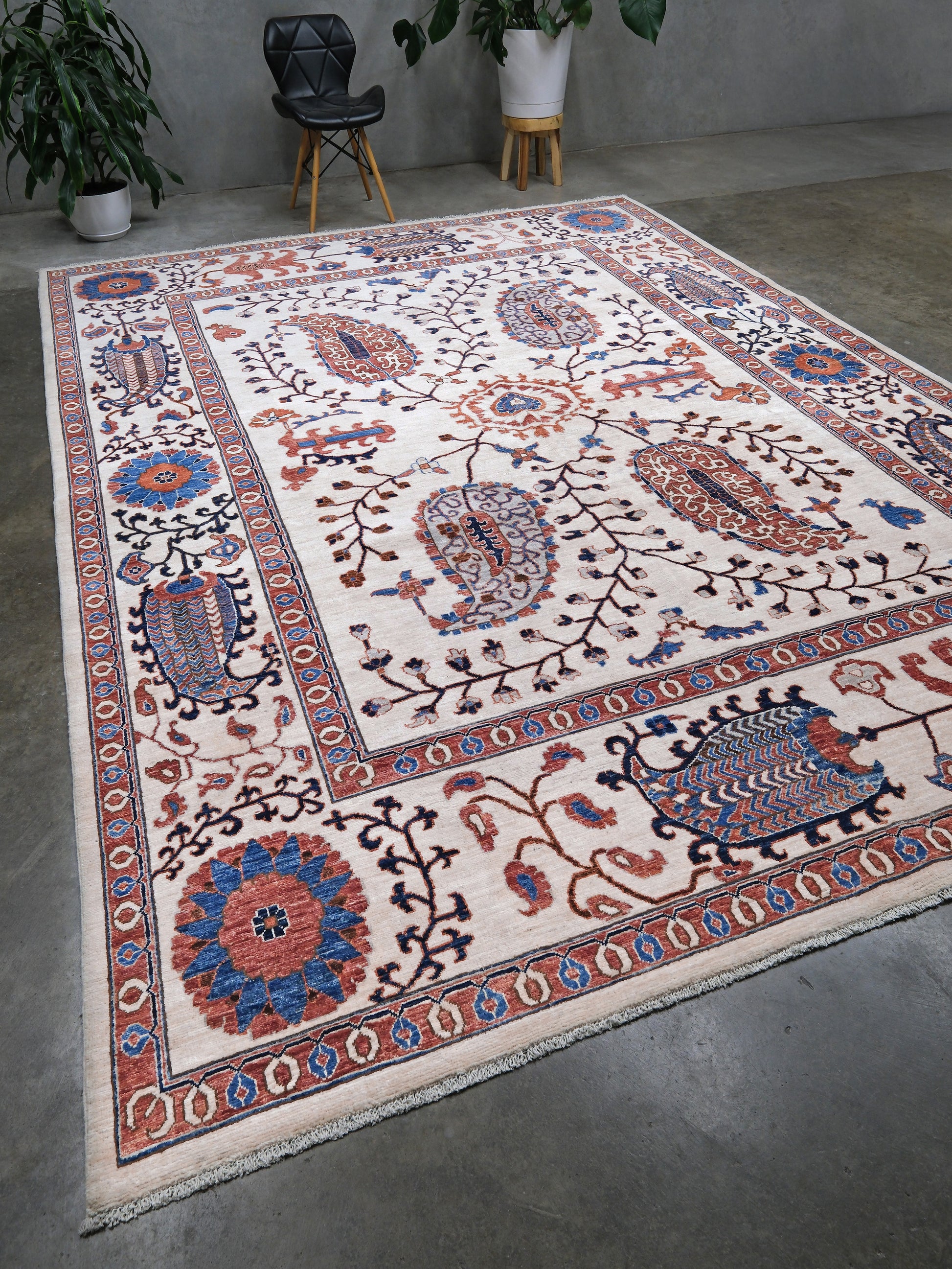 Ivory Suzani style handmade Turkish wool rug with paisley motifs, branching vines, flowers, indigo blue and rust accents, 9x12 from Indigo Rugs Burlingame Bay Area.