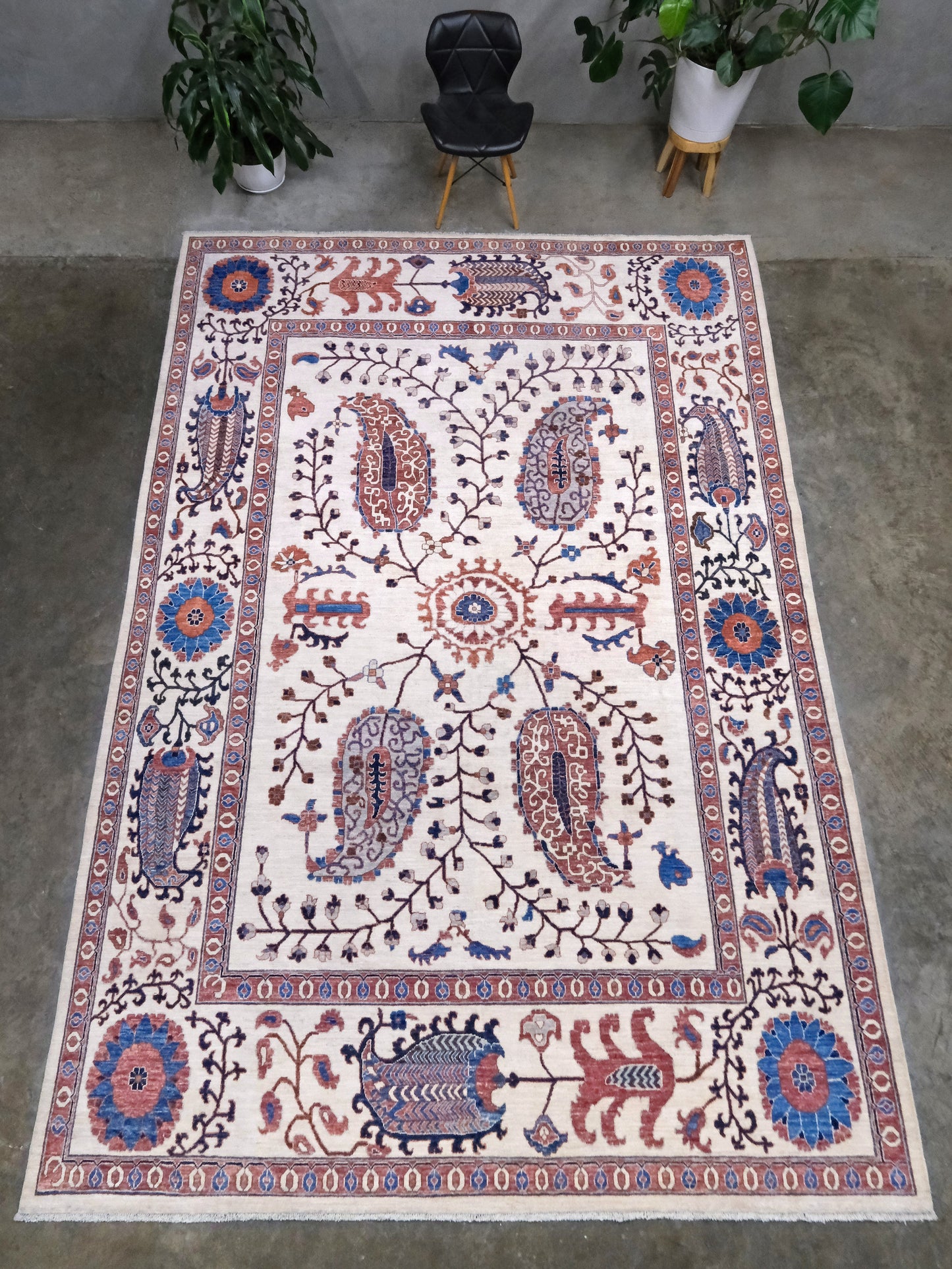 Ivory Suzani style handmade Turkish wool rug with paisley motifs, branching vines, flowers, indigo blue and rust accents, 9x12 from Indigo Rugs Burlingame Bay Area.