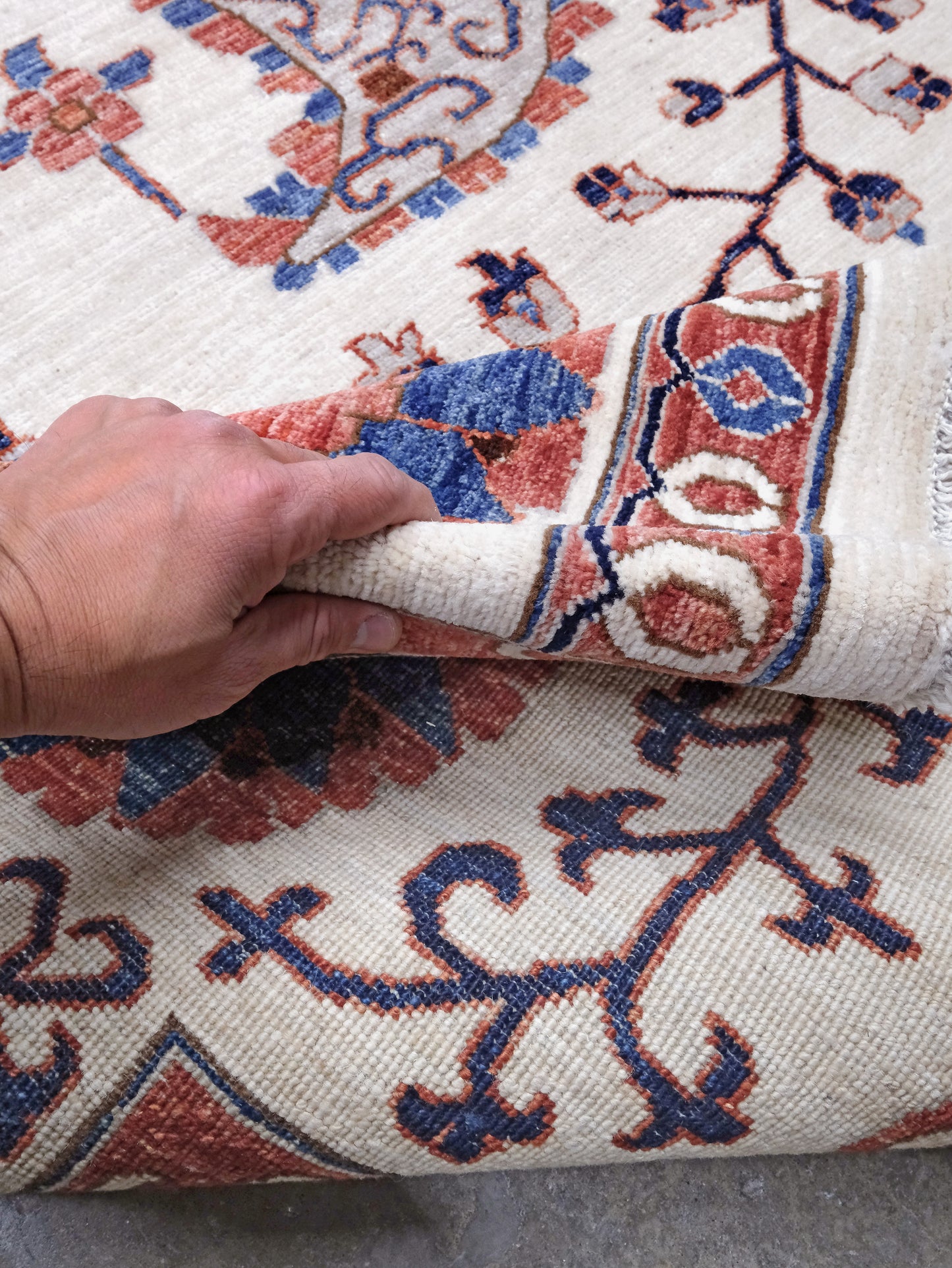 Ivory Suzani style handmade Turkish wool rug with paisley motifs, branching vines, flowers, indigo blue and rust accents, 9x12 from Indigo Rugs Burlingame Bay Area.