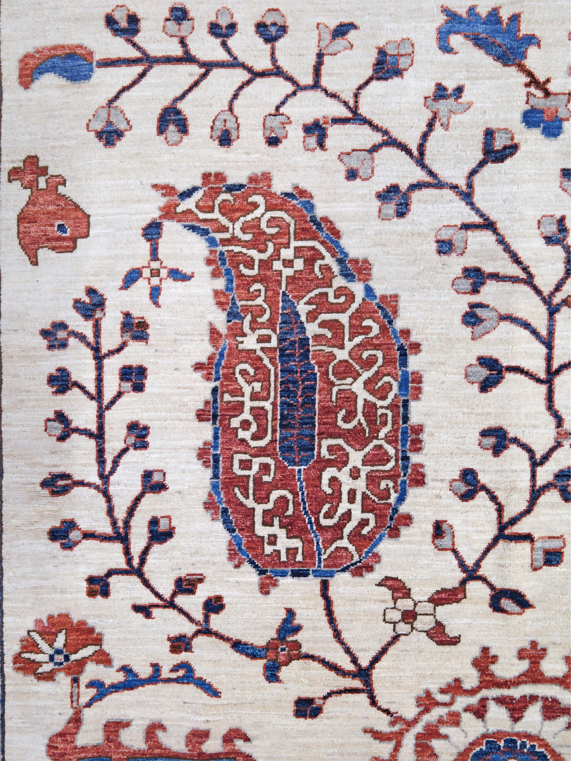 Ivory Suzani style handmade Turkish wool rug with paisley motifs, branching vines, flowers, indigo blue and rust accents, 9x12 from Indigo Rugs Burlingame Bay Area.