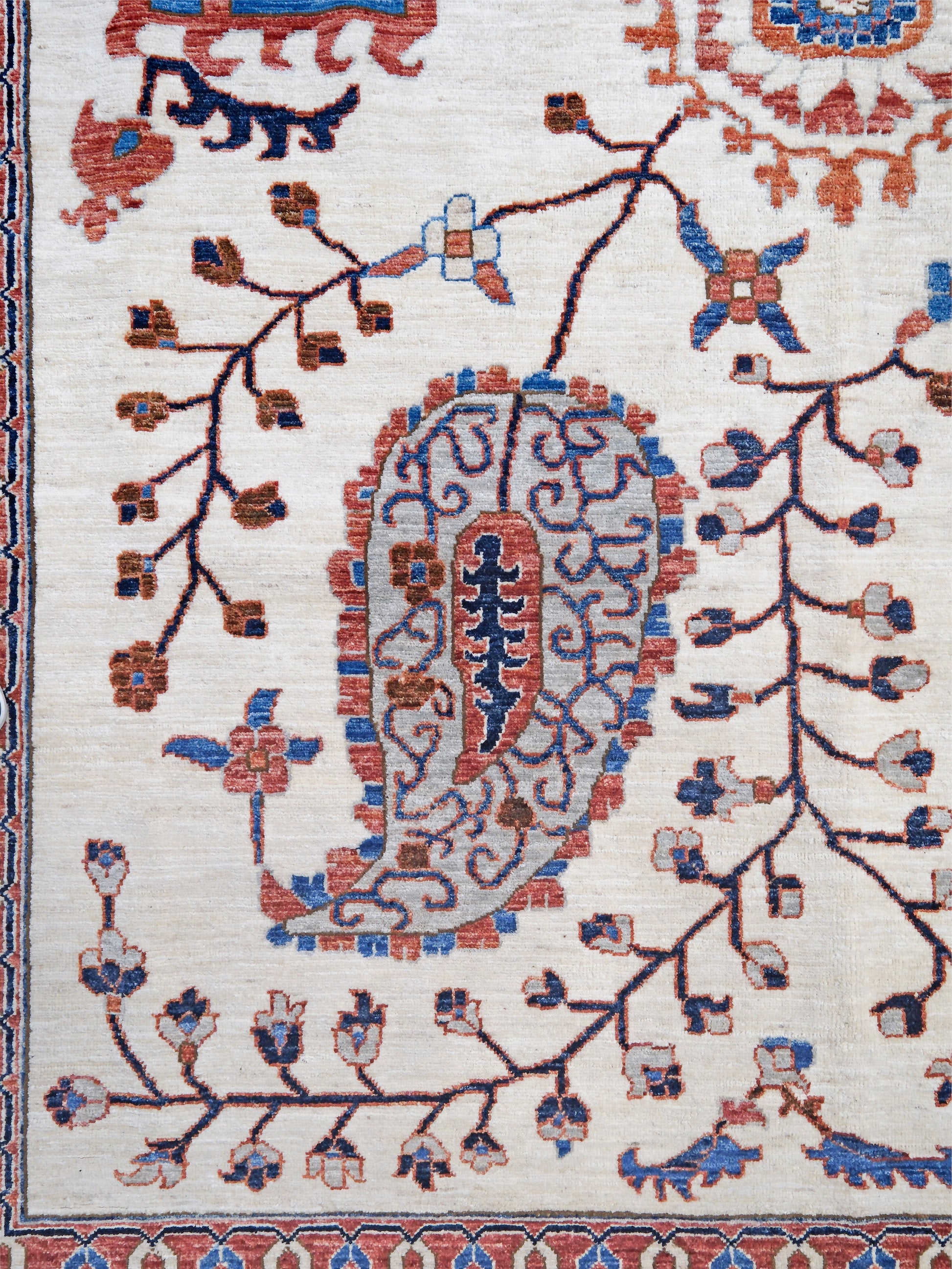 Ivory Suzani style handmade Turkish wool rug with paisley motifs, branching vines, flowers, indigo blue and rust accents, 9x12 from Indigo Rugs Burlingame Bay Area.