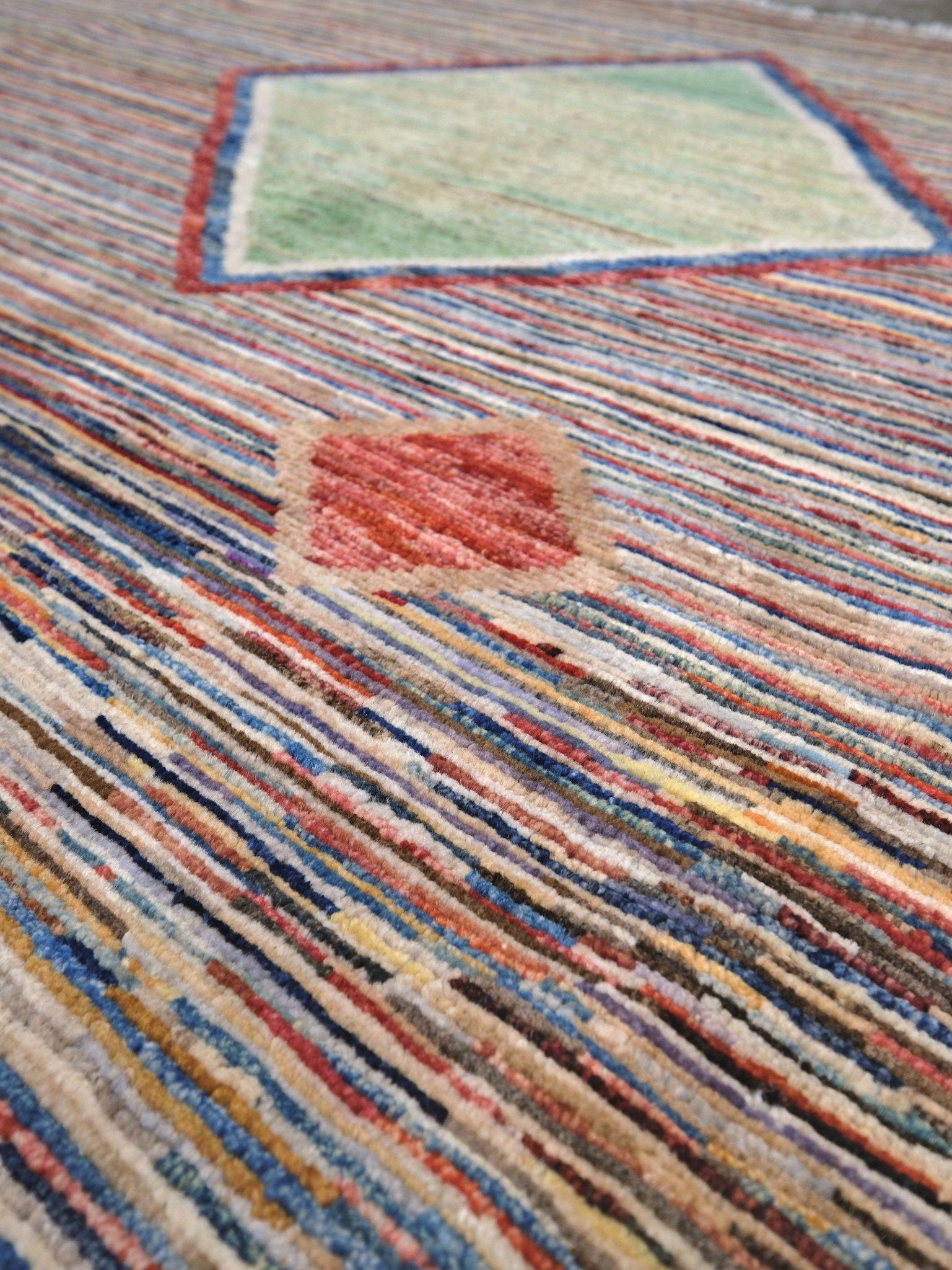 Modern Turkish Gabbeh style handmade wool rug with colorful diamond medallions on a striped field in blue, red, ivory, gray, green, camel and lavender, 7x10 from Indigo Rugs Burlingame Bay Area.