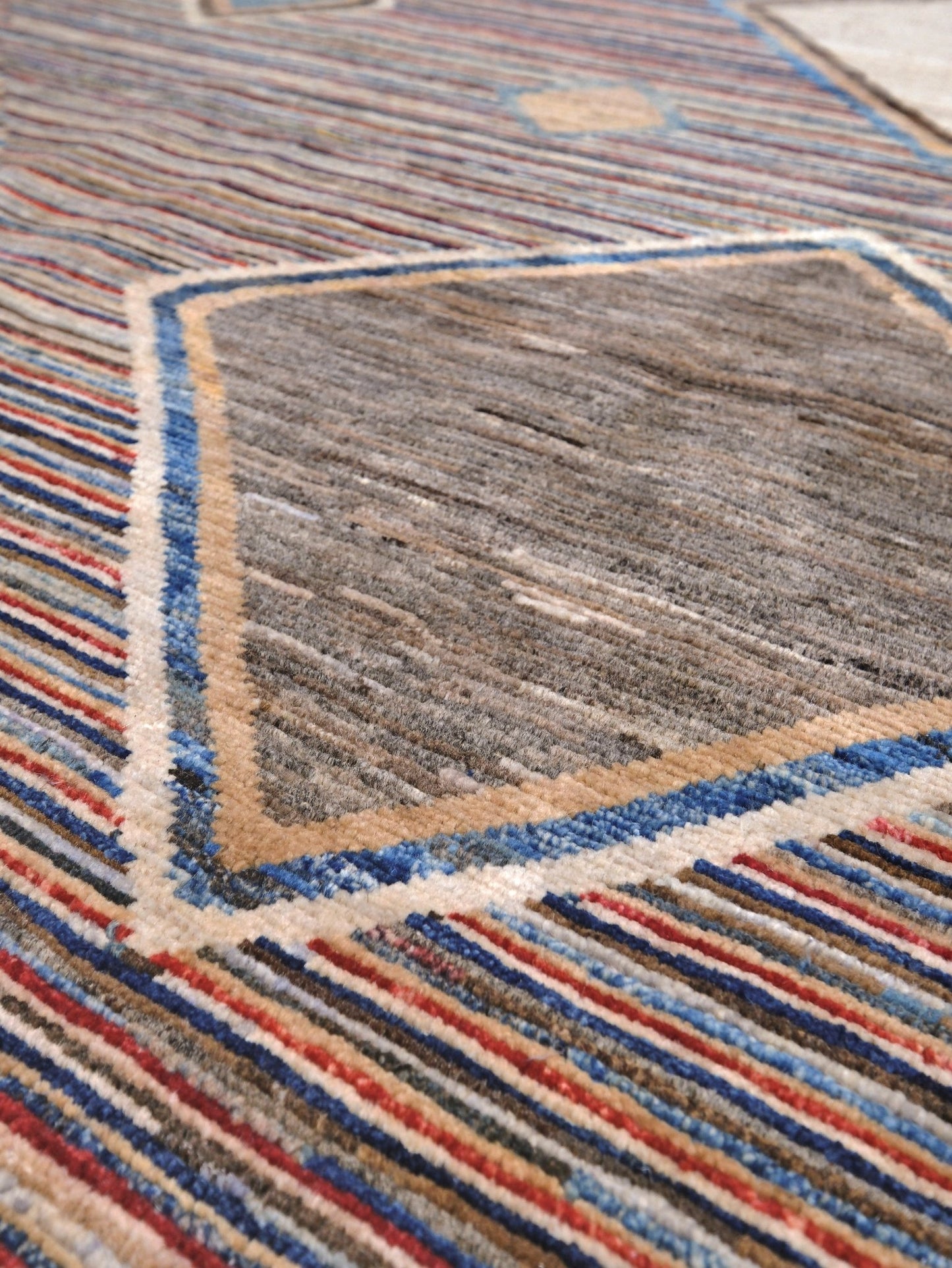 Modern Turkish Gabbeh style handmade wool rug with colorful diamond medallions on a striped field in blue, red, ivory, gray, green, camel and lavender, 7x10 from Indigo Rugs Burlingame Bay Area.