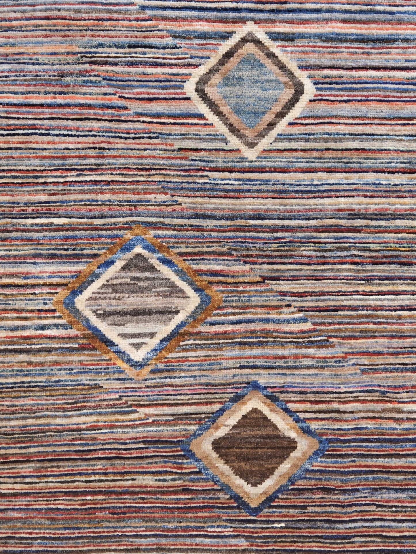 Modern Turkish Gabbeh style handmade wool rug with colorful diamond medallions on a striped field in blue, red, ivory, gray, green, camel and lavender, 7x10 from Indigo Rugs Burlingame Bay Area.