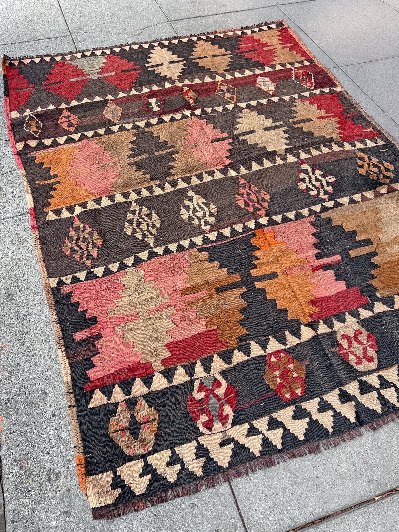 5x7 Kurdish Kilim rug from Eastern Turkey in slitweave technique, featuring bold geometric patterns in red, pink, and earthy tones. Offered by the best Kilim rug store in the San Francisco Bay Area, with free shipping to the US and Canada. A perfect gift idea for this season.