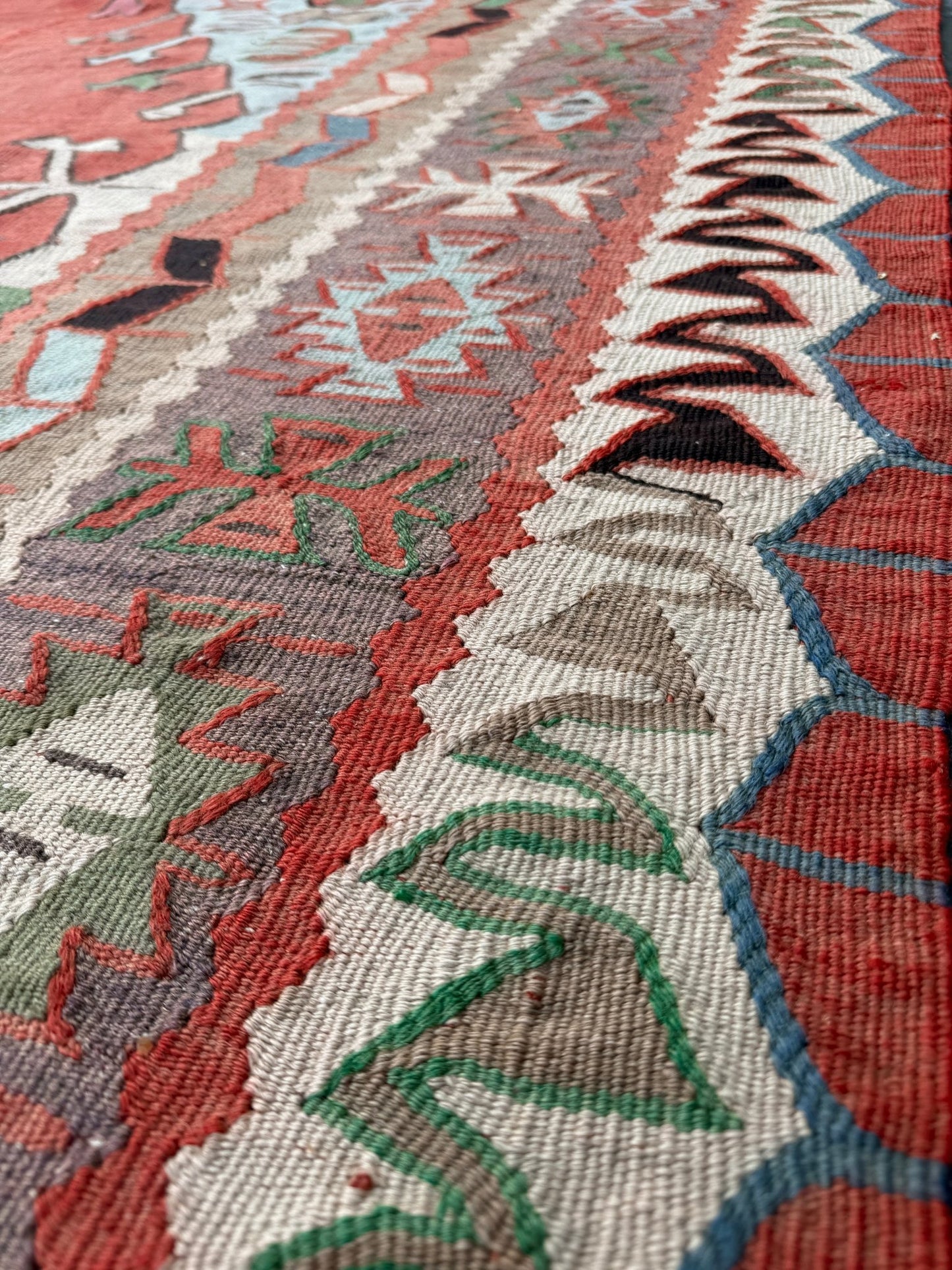 4x10 vintage Turkish Oushak kilim rug with a dusty rose field, geometric tribal medallion, and soft sage, mint, and blue accents — handmade flatweave wool rug from the 1940s, naturally dyed and beautifully aged with mellowed colors and small, well-executed repairs. Perfect for living room or bohemian interior décor — Indigo Rugs.