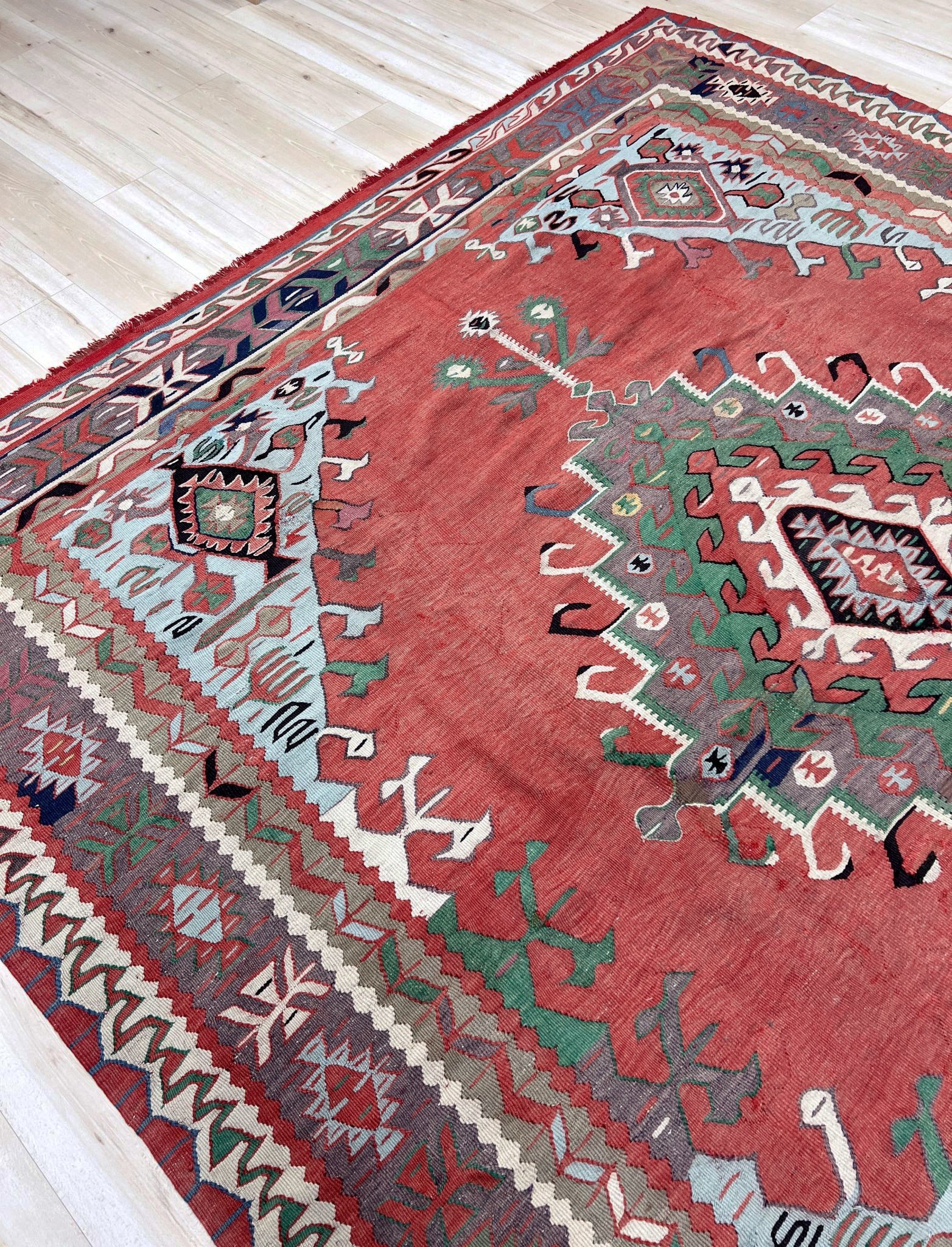 4x10 vintage Turkish Oushak kilim rug with a dusty rose field, geometric tribal medallion, and soft sage, mint, and blue accents — handmade flatweave wool rug from the 1940s, naturally dyed and beautifully aged with mellowed colors and small, well-executed repairs. Perfect for living room or bohemian interior décor — Indigo Rugs.