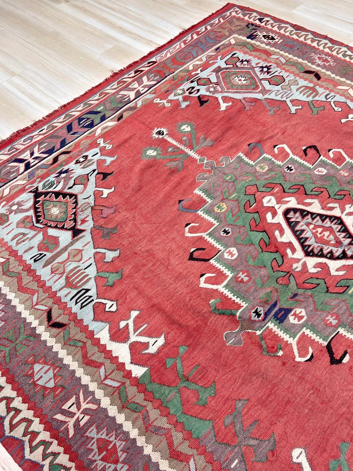 8x10 vintage Turkish Oushak kilim rug with a dusty rose field, geometric tribal medallion, and soft sage, mint, and blue accents — handmade flatweave wool rug from the 1940s