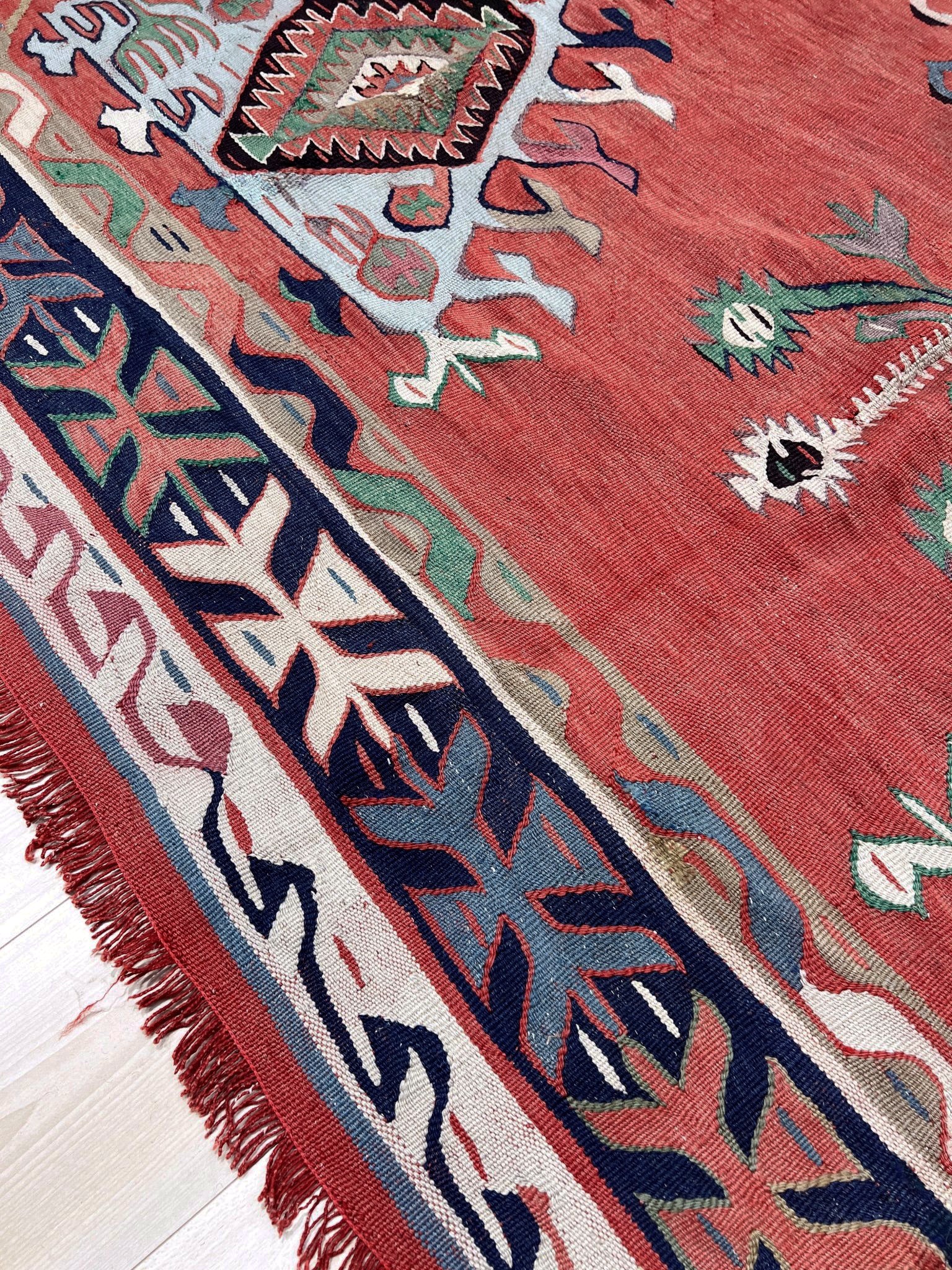 4x10 vintage Turkish Oushak kilim rug with a dusty rose field, geometric tribal medallion, and soft sage, mint, and blue accents — handmade flatweave wool rug from the 1940s, naturally dyed and beautifully aged with mellowed colors and small, well-executed repairs. Perfect for living room or bohemian interior décor — Indigo Rugs.