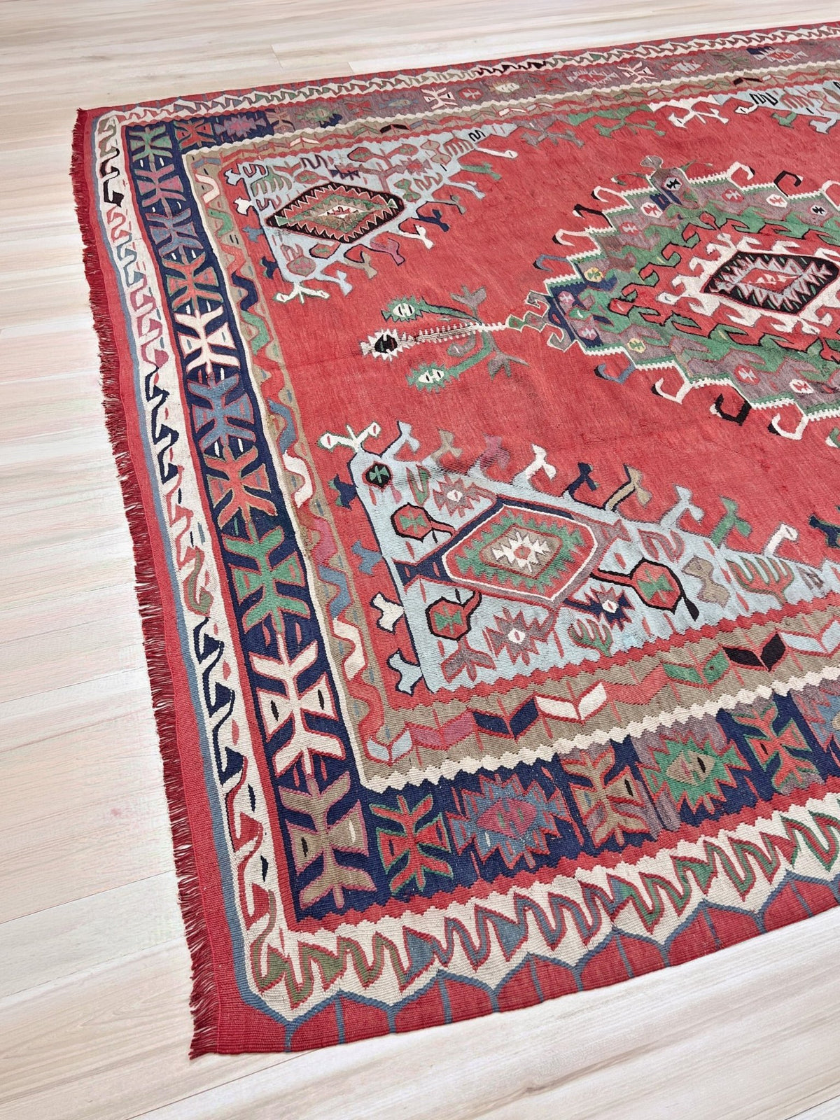 8x10 vintage Turkish Oushak kilim rug with a dusty rose field, geometric tribal medallion, and soft sage, mint, and blue accents — handmade flatweave wool rug from the 1940s