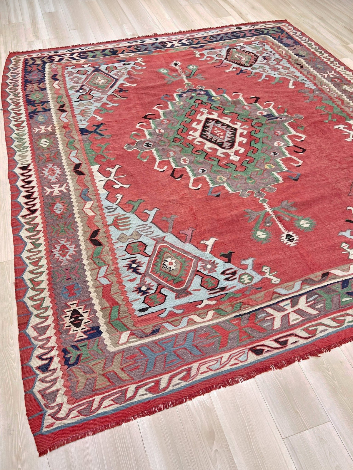 8x10 vintage Turkish Oushak kilim rug with a dusty rose field, geometric tribal medallion, and soft sage, mint, and blue accents — handmade flatweave wool rug from the 1940s
