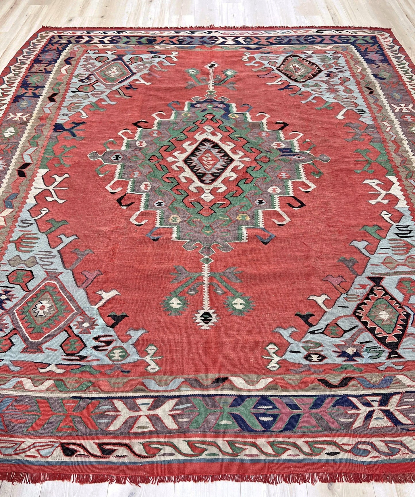 4x10 vintage Turkish Oushak kilim rug with a dusty rose field, geometric tribal medallion, and soft sage, mint, and blue accents — handmade flatweave wool rug from the 1940s, naturally dyed and beautifully aged with mellowed colors and small, well-executed repairs. Perfect for living room or bohemian interior décor — Indigo Rugs.