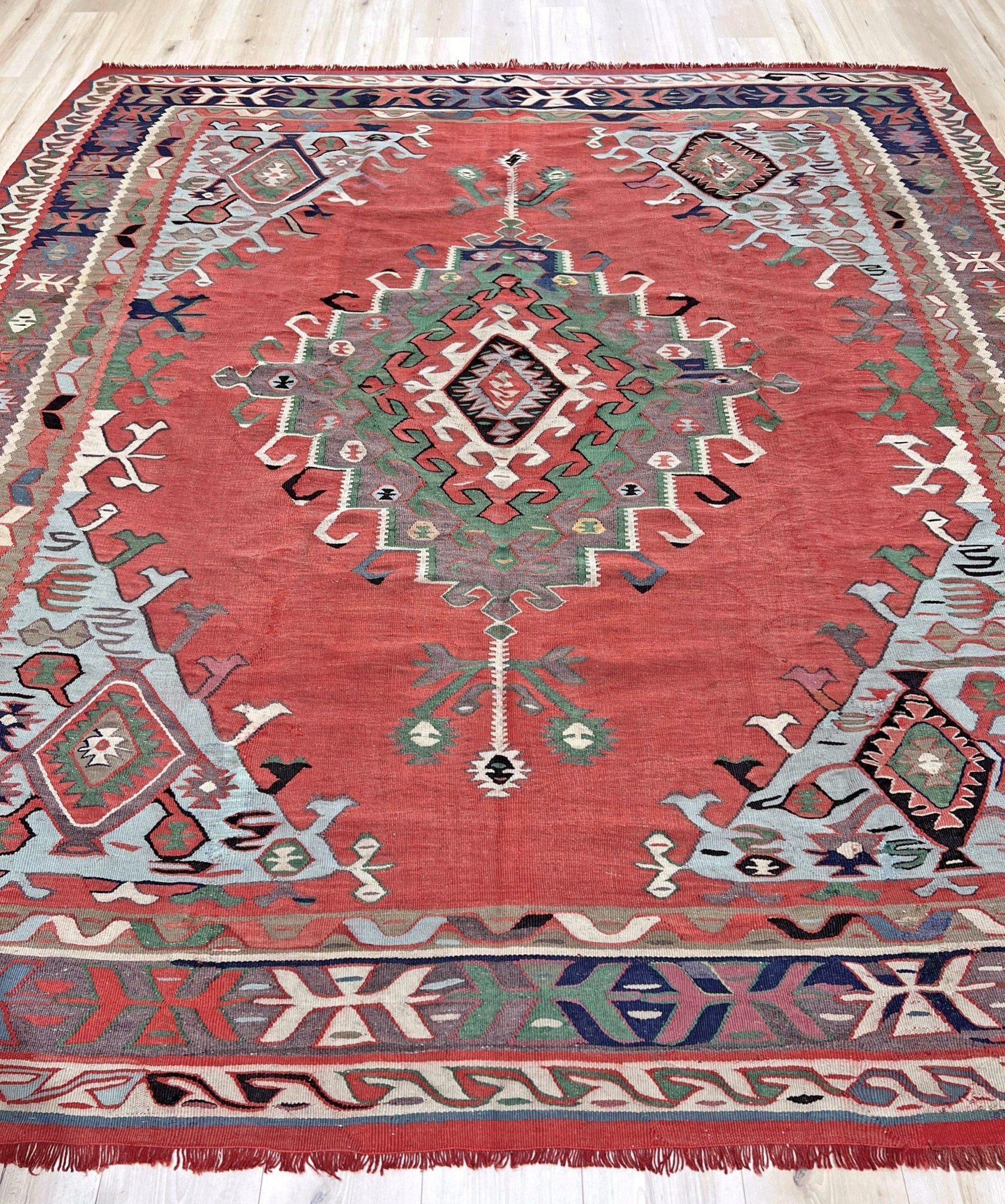 4x10 vintage Turkish Oushak kilim rug with a dusty rose field, geometric tribal medallion, and soft sage, mint, and blue accents — handmade flatweave wool rug from the 1940s, naturally dyed and beautifully aged with mellowed colors and small, well-executed repairs. Perfect for living room or bohemian interior décor — Indigo Rugs.