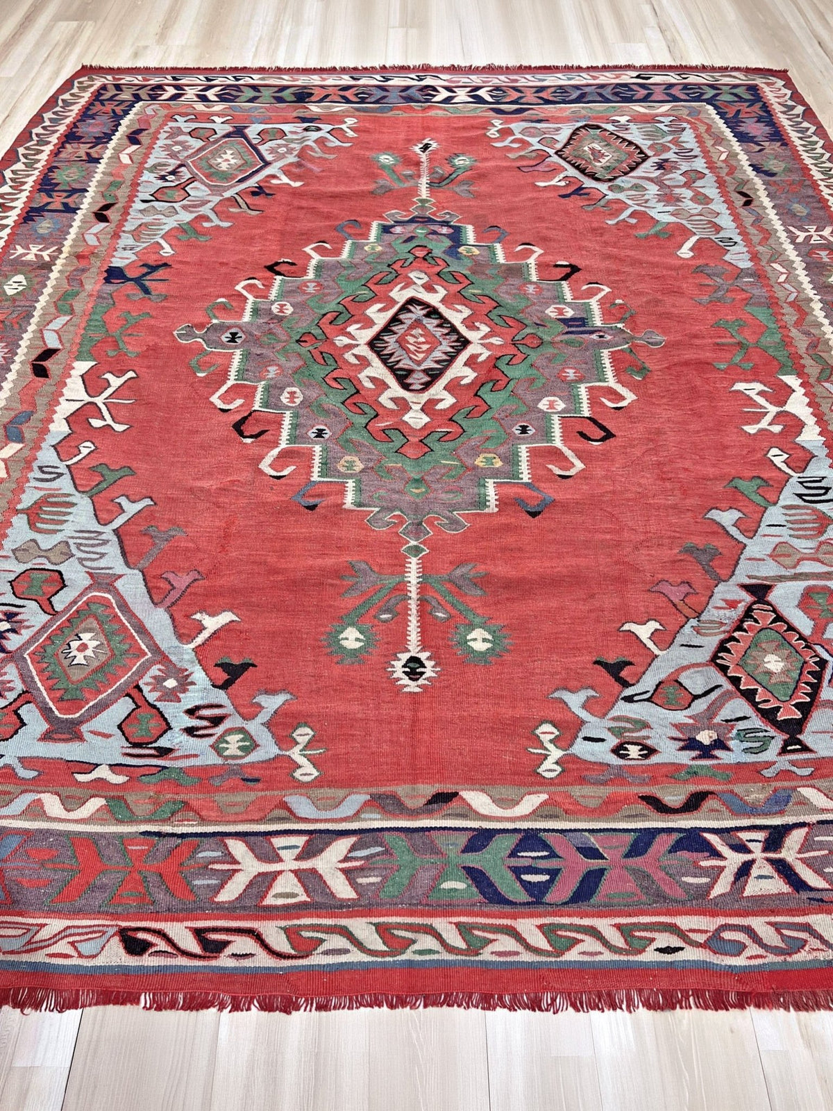 8x10 vintage Turkish Oushak kilim rug with a dusty rose field, geometric tribal medallion, and soft sage, mint, and blue accents — handmade flatweave wool rug from the 1940s