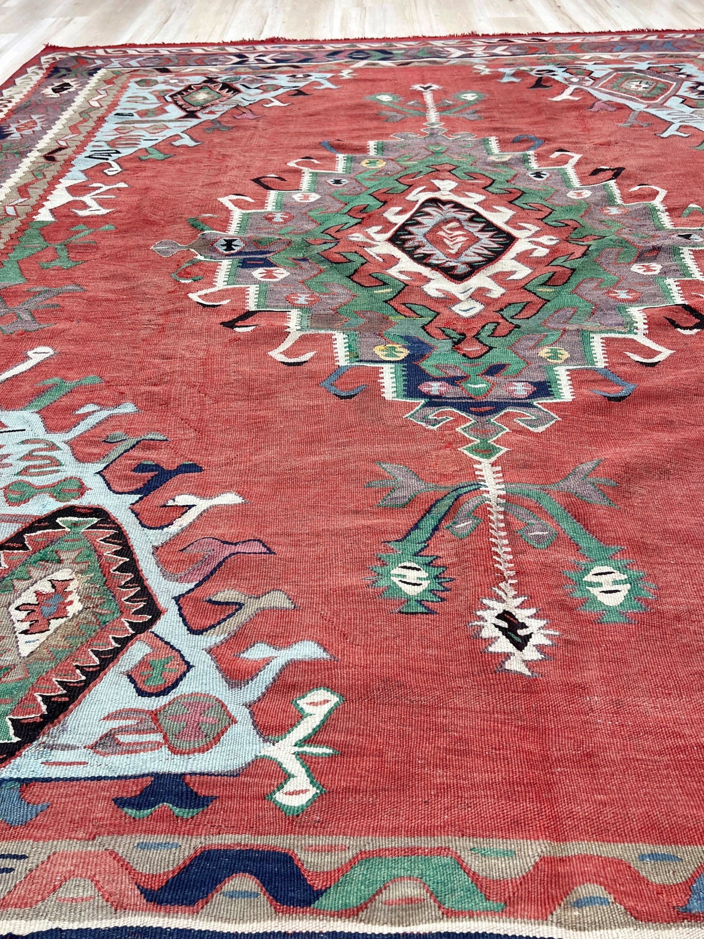 4x10 vintage Turkish Oushak kilim rug with a dusty rose field, geometric tribal medallion, and soft sage, mint, and blue accents — handmade flatweave wool rug from the 1940s, naturally dyed and beautifully aged with mellowed colors and small, well-executed repairs. Perfect for living room or bohemian interior décor — Indigo Rugs.