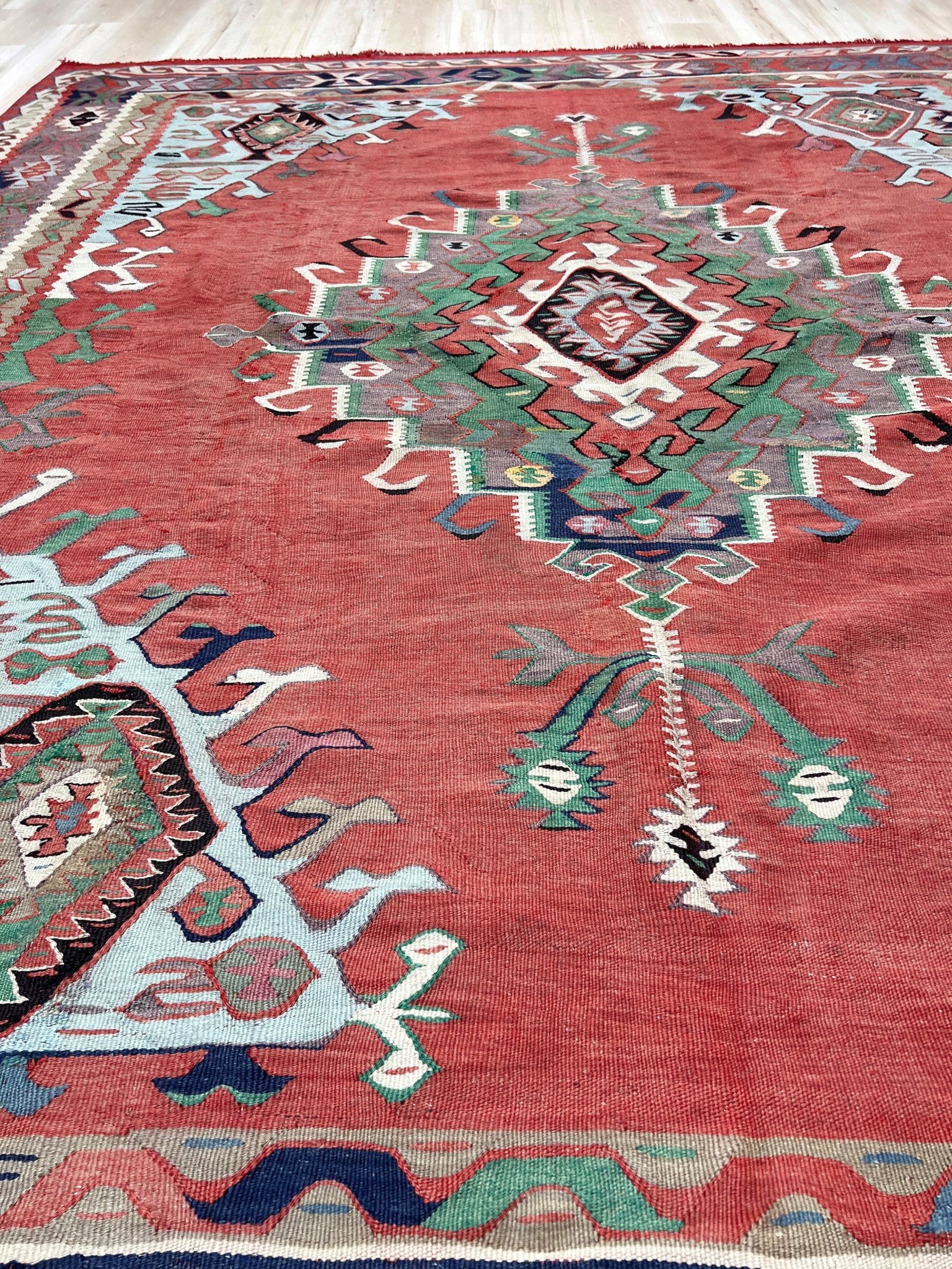 4x10 vintage Turkish Oushak kilim rug with a dusty rose field, geometric tribal medallion, and soft sage, mint, and blue accents — handmade flatweave wool rug from the 1940s, naturally dyed and beautifully aged with mellowed colors and small, well-executed repairs. Perfect for living room or bohemian interior décor — Indigo Rugs.