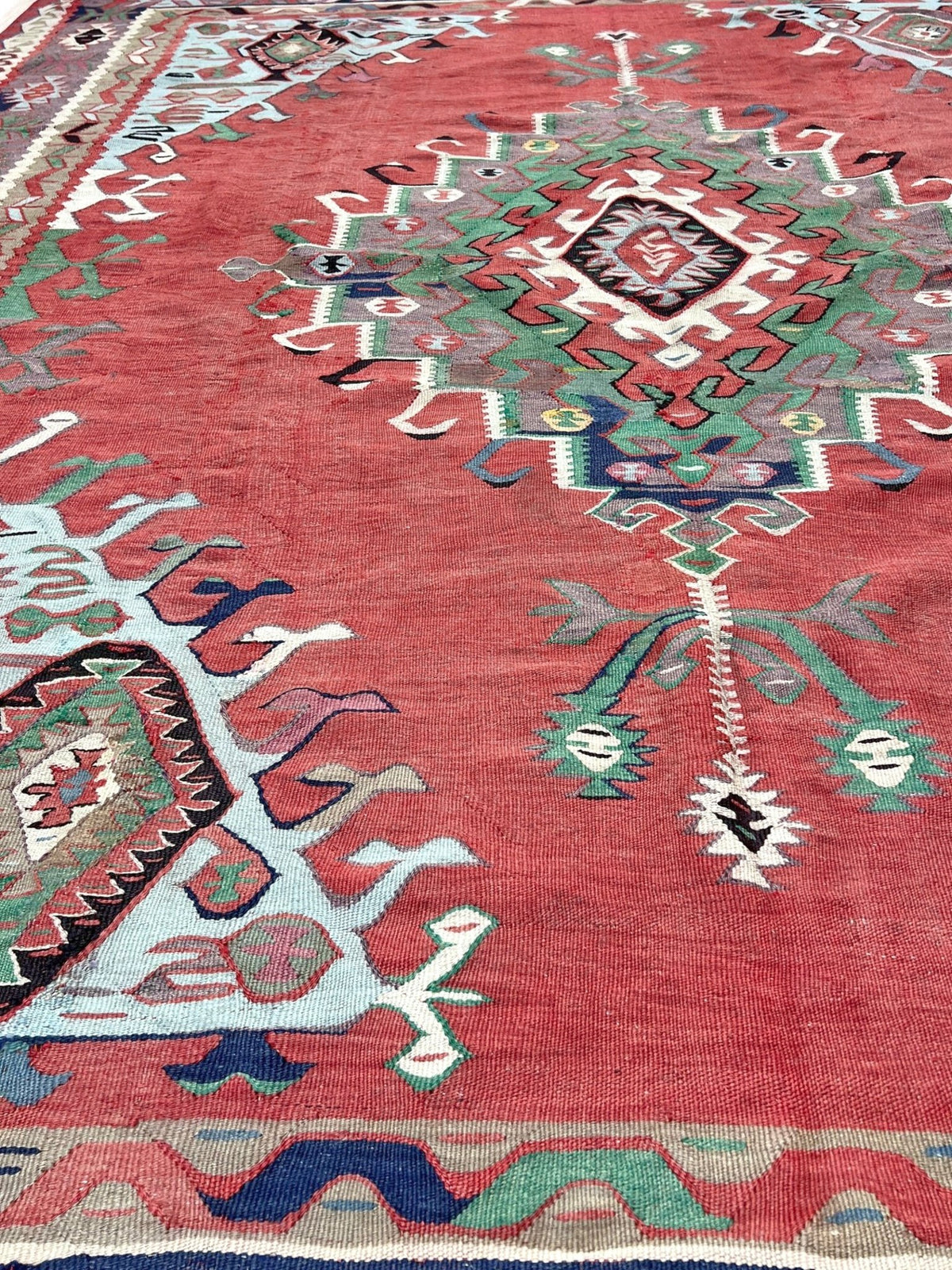 8x10 vintage Turkish Oushak kilim rug with a dusty rose field, geometric tribal medallion, and soft sage, mint, and blue accents — handmade flatweave wool rug from the 1940s