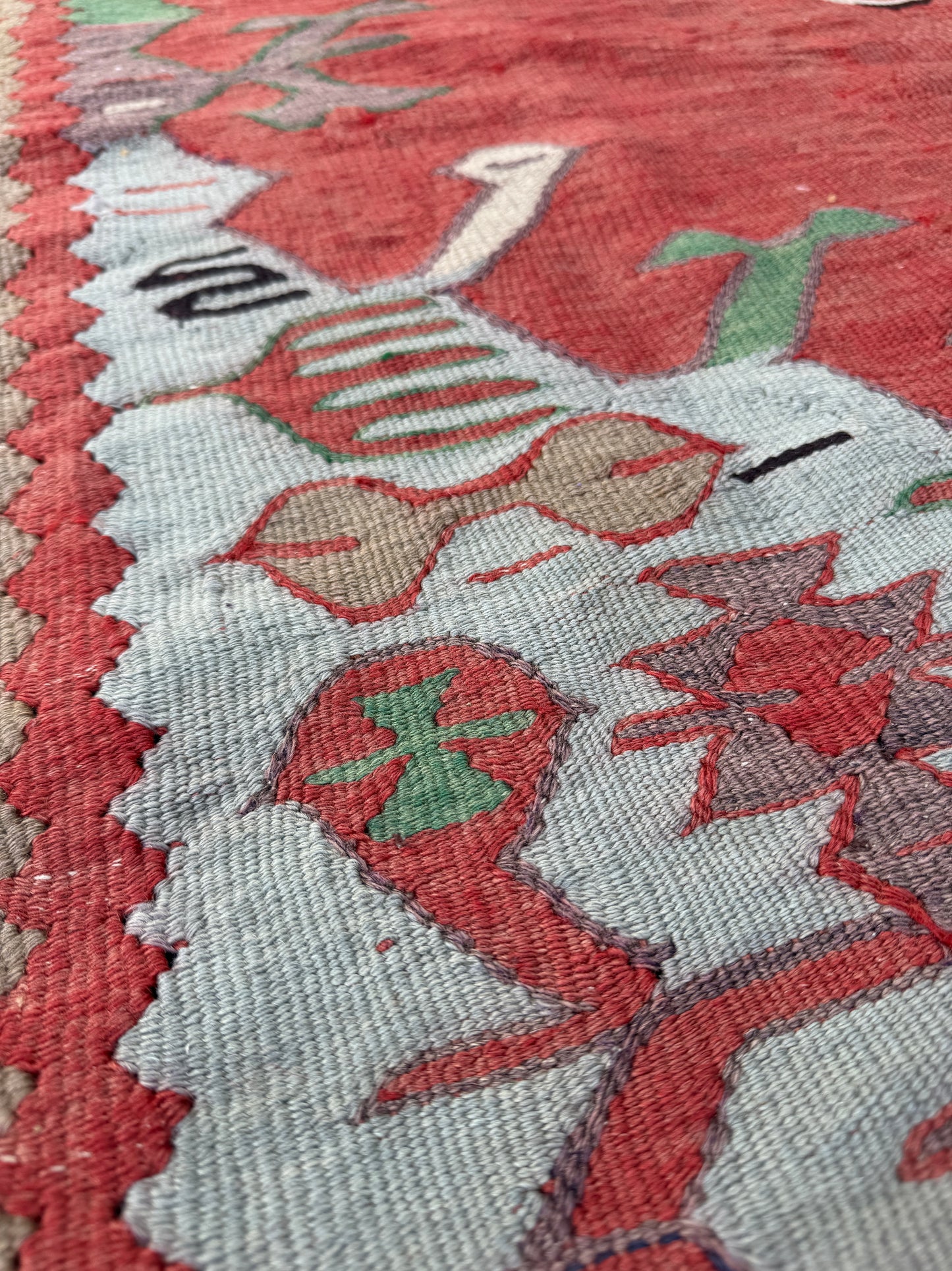 4x10 vintage Turkish Oushak kilim rug with a dusty rose field, geometric tribal medallion, and soft sage, mint, and blue accents — handmade flatweave wool rug from the 1940s, naturally dyed and beautifully aged with mellowed colors and small, well-executed repairs. Perfect for living room or bohemian interior décor — Indigo Rugs.