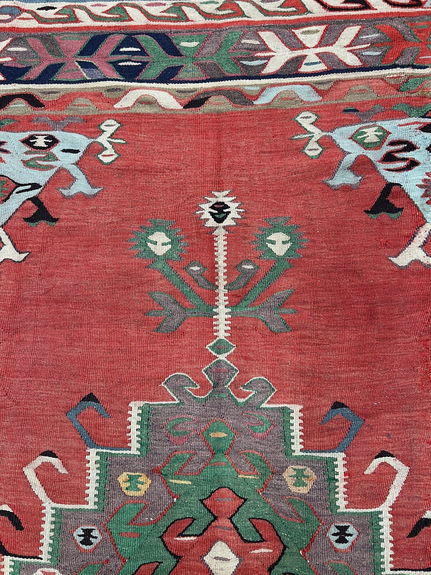 4x10 vintage Turkish Oushak kilim rug with a dusty rose field, geometric tribal medallion, and soft sage, mint, and blue accents — handmade flatweave wool rug from the 1940s, naturally dyed and beautifully aged with mellowed colors and small, well-executed repairs. Perfect for living room or bohemian interior décor — Indigo Rugs.