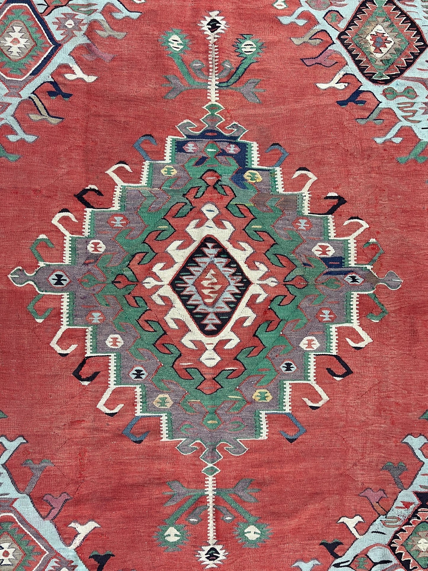 4x10 vintage Turkish Oushak kilim rug with a dusty rose field, geometric tribal medallion, and soft sage, mint, and blue accents — handmade flatweave wool rug from the 1940s, naturally dyed and beautifully aged with mellowed colors and small, well-executed repairs. Perfect for living room or bohemian interior décor — Indigo Rugs.