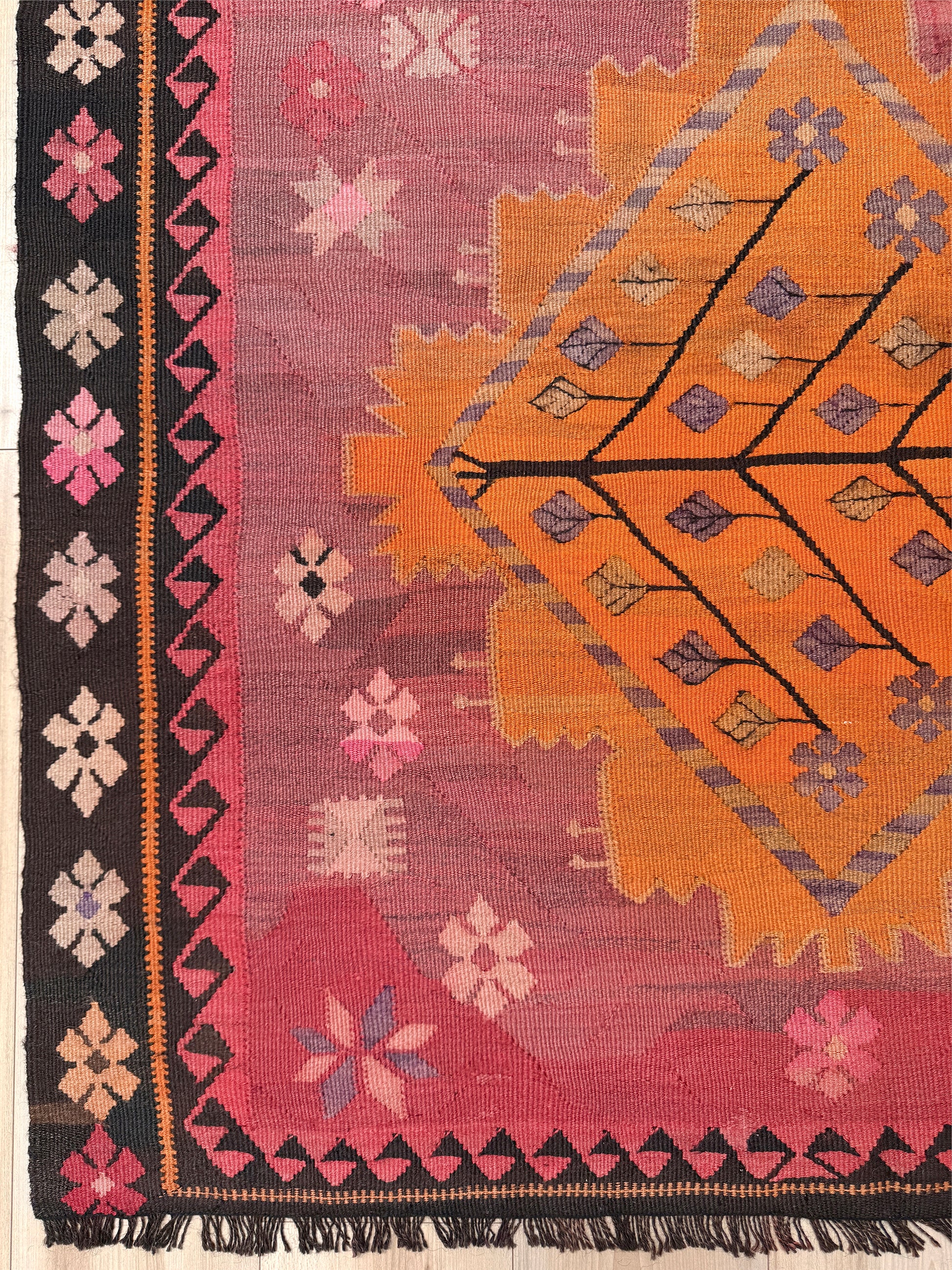 Colorful patterned rug with geometric and floral designs on a pink background. Vintage Kars Turkish kilim rug in dusty pink, warm apricot orange, handwoven from Anatolian wool 5x10. 