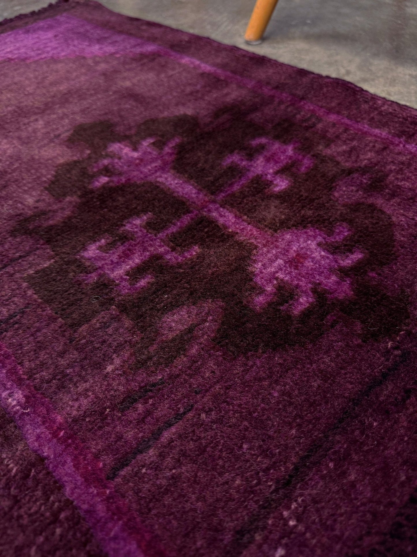 Vintage Turkish overdyed Yastik rug in plum, aubergine, and magenta purple with a shadowed black medallion. Hand-knotted wool, 19x38 inches. One-of-a-kind rug from Indigo Rugs in Burlingame, the best rug shop in the San Francisco Bay Area. Free shipping included.