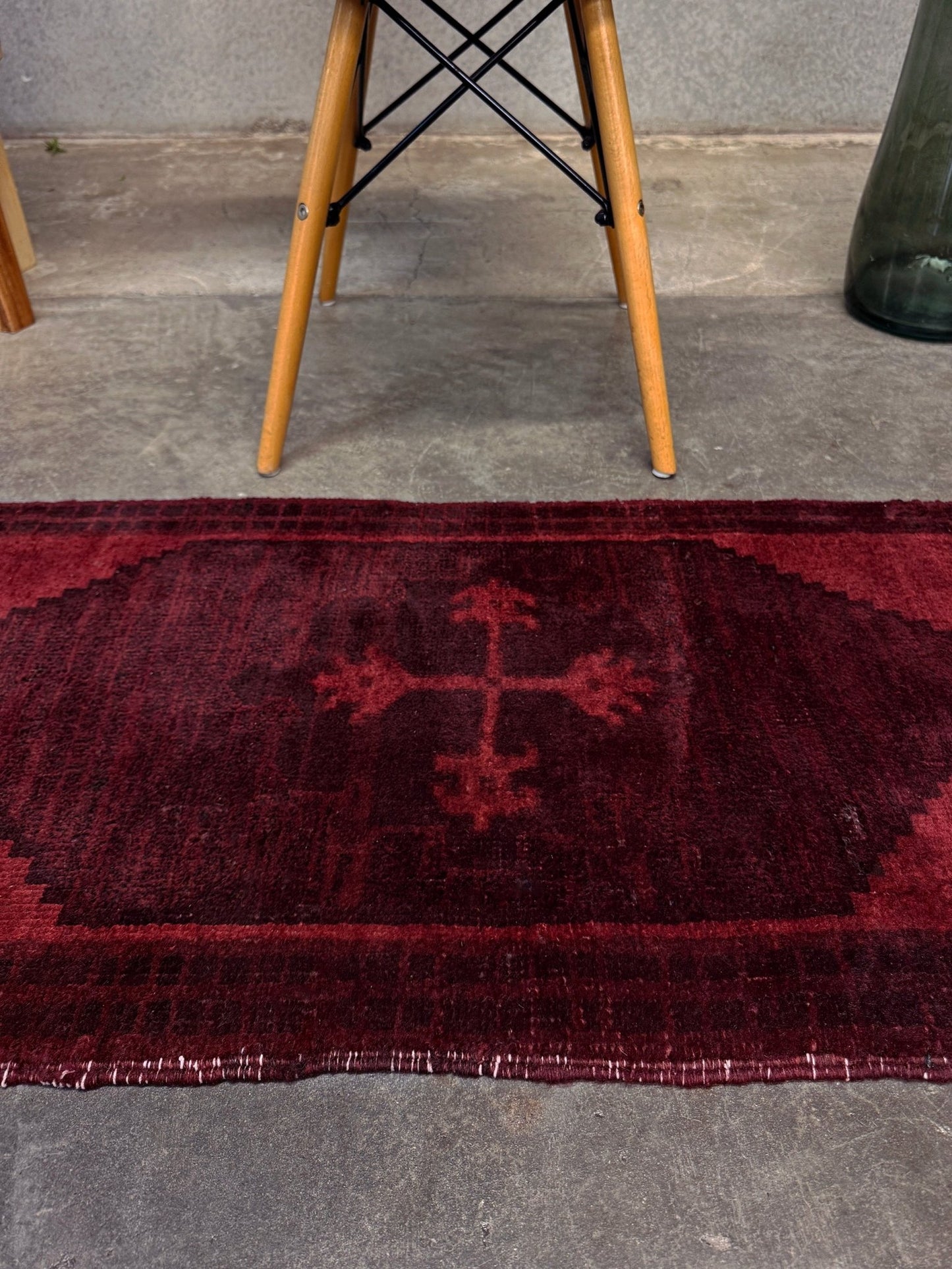 Vintage Turkish overdyed Yastik rug in ruby red tones with subtle shadowed motifs. Hand-knotted wool, 18x40 inches. Perfect for: Entryway, apartment foyers, beside the bed, kitchen sink areas, bathroom vanity spots, layered under décor piecesOne-of-a-kind rug from Indigo Rugs in Burlingame, the best rug shop in the San Francisco Bay Area. Free shipping included.