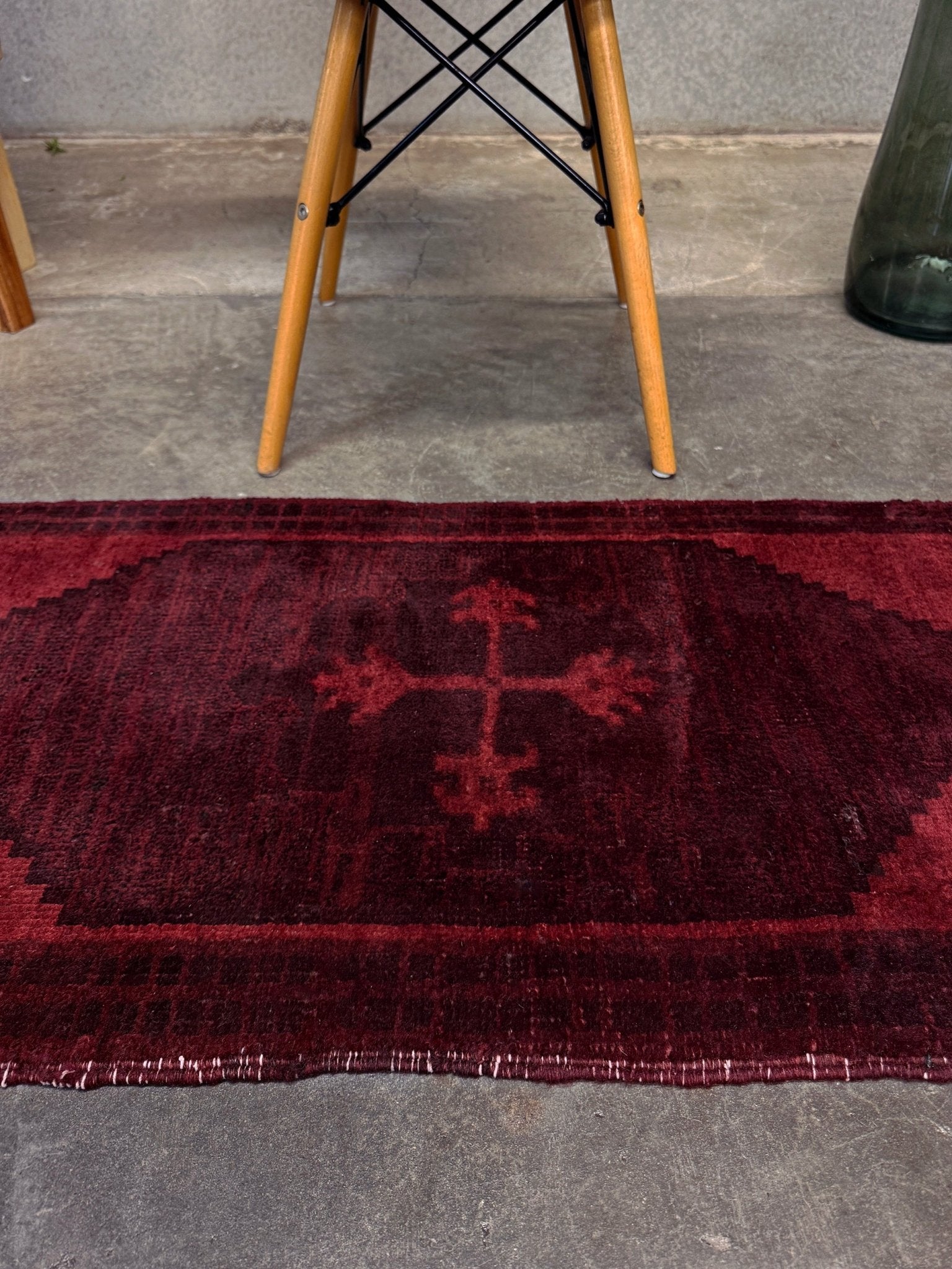 Vintage Turkish overdyed Yastik rug in ruby red tones with subtle shadowed motifs. Hand-knotted wool, 18x40 inches. Perfect for: Entryway, apartment foyers, beside the bed, kitchen sink areas, bathroom vanity spots, layered under décor piecesOne-of-a-kind rug from Indigo Rugs in Burlingame, the best rug shop in the San Francisco Bay Area. Free shipping included.