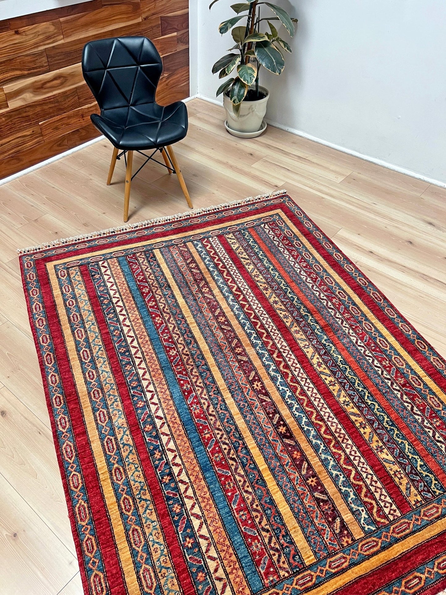 Side view of Handmade Turkish Shawl Rug with vibrant vertical stripes in red, blue, yellow, and cream, featuring intricate tribal motifs from the best luxury rug shop in the San Francisco Bay Area. High-quality wool rug at an affordable price with free shipping. Perfect for adding a touch of Turkish craftsmanship to any room. Ideal statement piece for living rooms, bedrooms, and entryways.