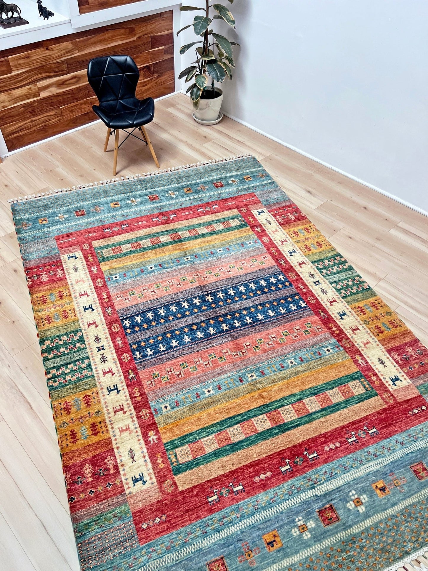 side view of Colorful handmade Gabbeh rug with animal motifs in rich brick red, soft sky blue, teal, golden mustard yellow, forest green, and cream hues from the best luxury handmade rug shop in the San Francisco Bay Area. Premium quality wool rug featuring vibrant stripes and tribal design elements. Perfect as a statement piece for living rooms and cozy spaces. Free shipping available.