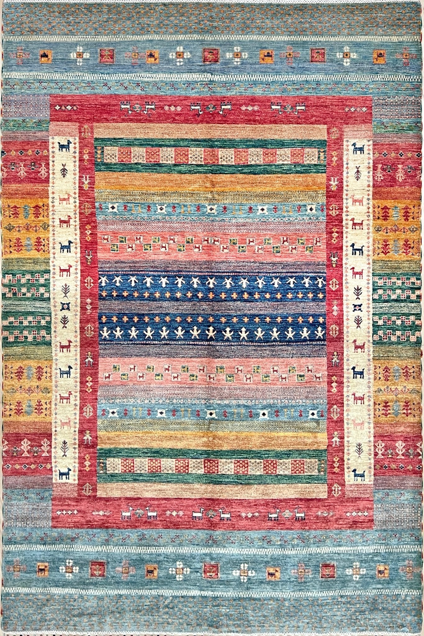 Colorful handmade Gabbeh rug with animal motifs in rich brick red, soft sky blue, teal, golden mustard yellow, forest green, and cream hues from the best luxury handmade rug shop in the San Francisco Bay Area. Premium quality wool rug featuring vibrant stripes and tribal design elements. Perfect as a statement piece for living rooms and cozy spaces. Free shipping available.