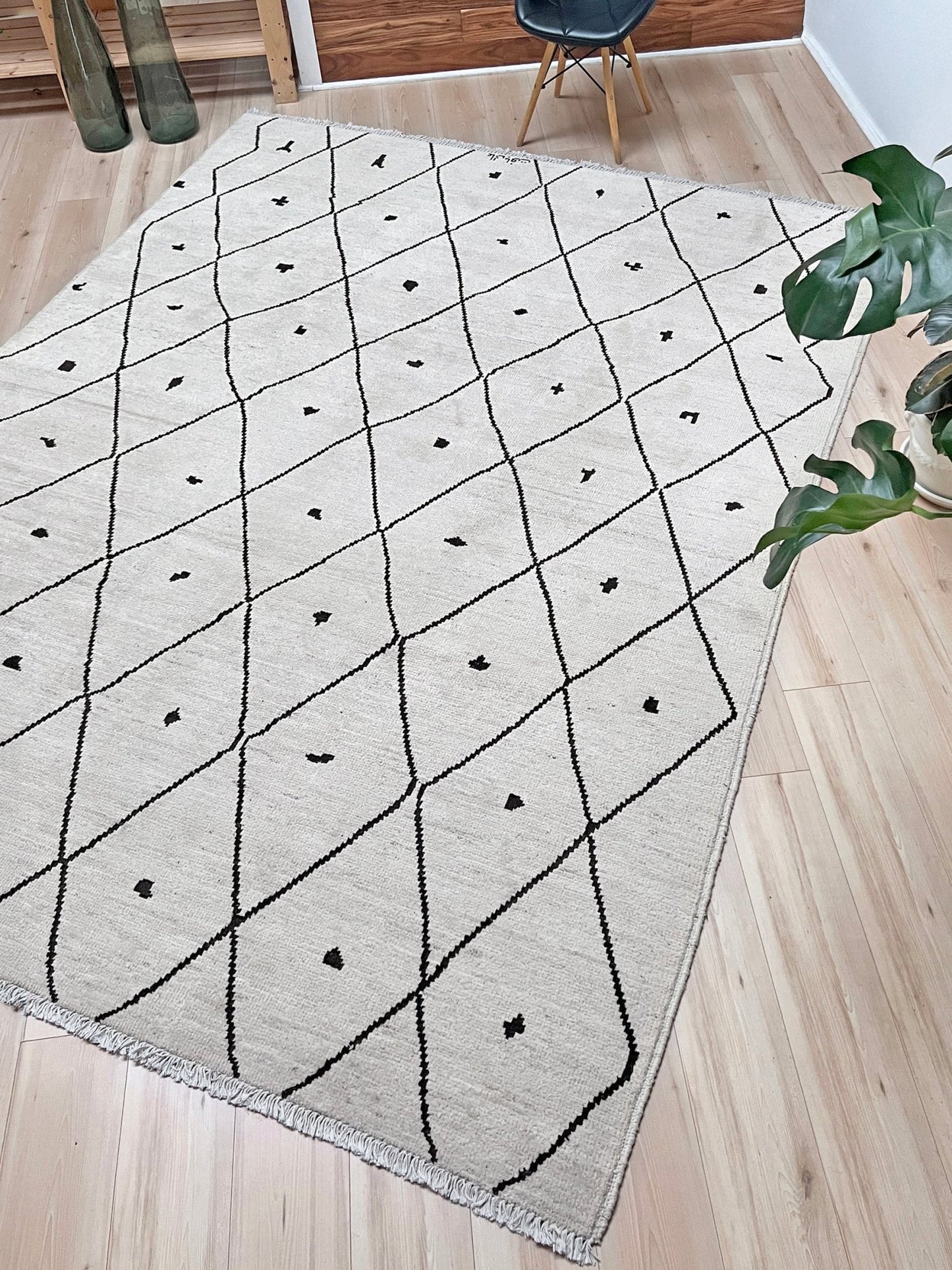 Gray rug with black geometric pattern on a wooden floor. handmade moroccan inspired minimalist rug 8x10 ivory wool rug black diamond lattice modern moroccan style area rug large neutral wool rug indigo rugs san francisco bay area