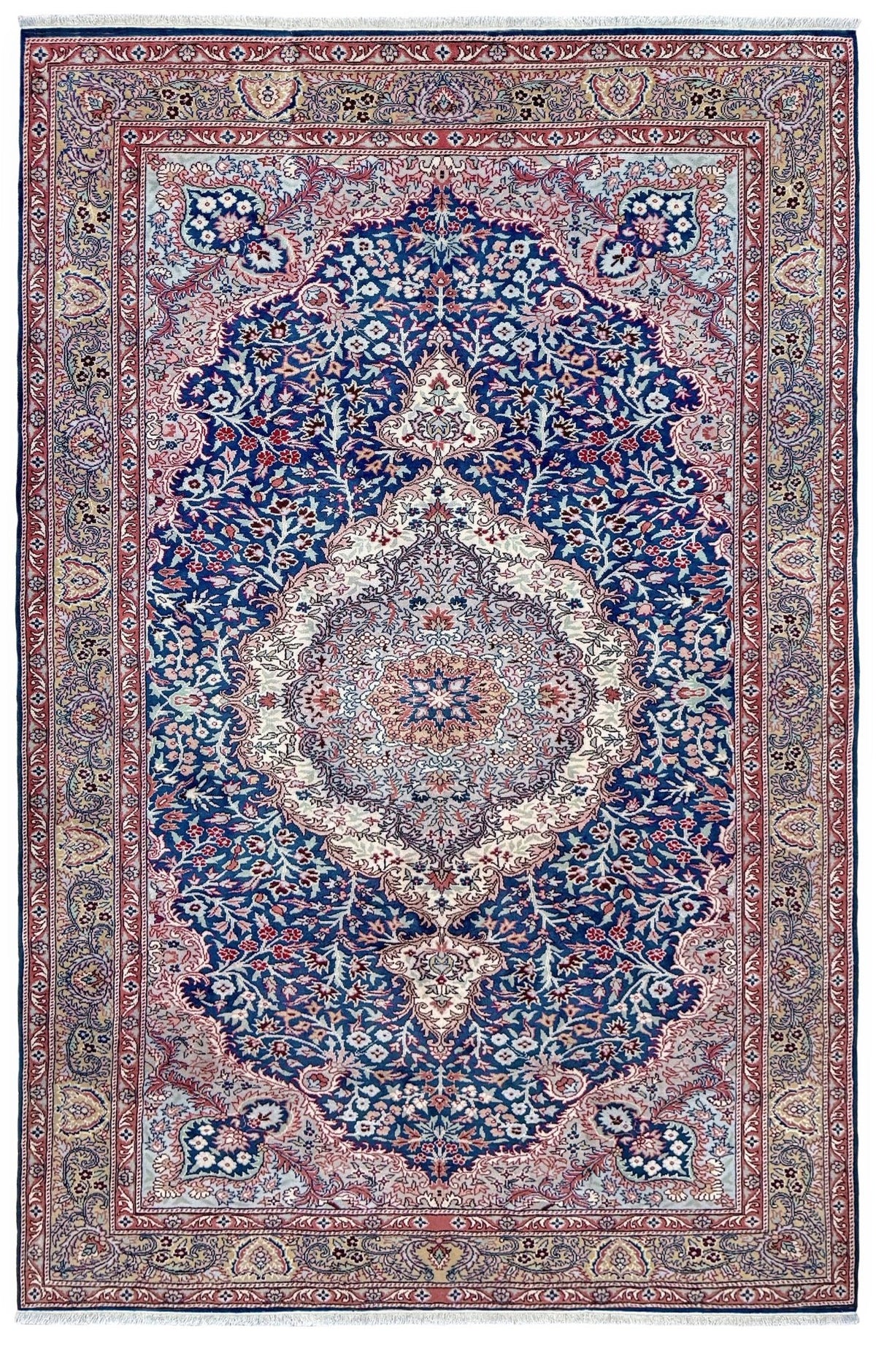 A traditional Persian-style area rug with a central medallion, featuring a dominant navy blue field, a dusty pink border, and cream and red accents in an intricate floral and vine pattern. Blue vintage Turkish rug with deep blue field,  floral medallion, handmade wool 7x9 from Indigo Rugs Burlingame Bay Area.