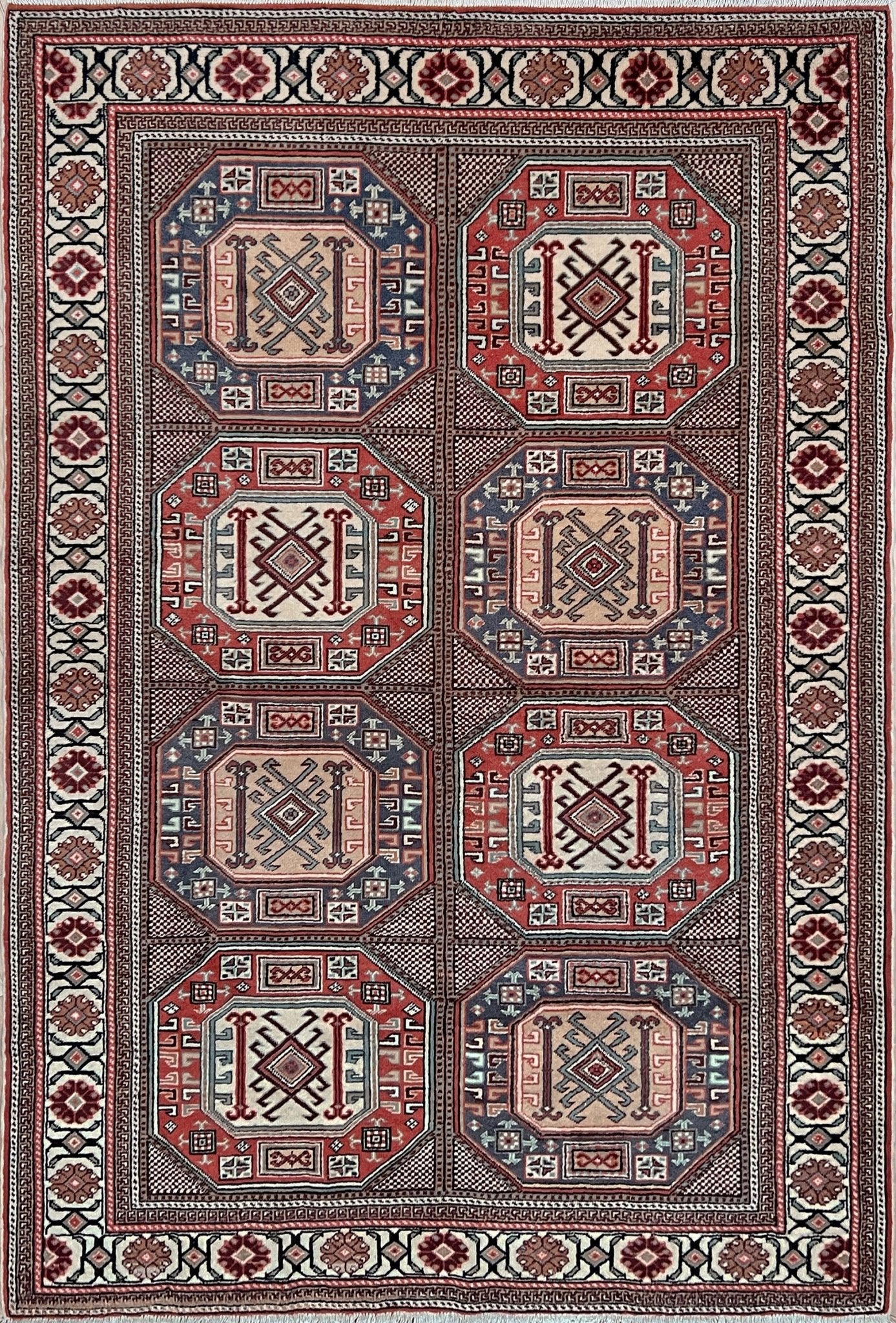 Luxurious 5x7 Turkish tribal rug with geometric 'chest' octagonal medallions and intricate checkered pattern in brick red, deep navy blue, ivory cream, and dusty peach hues. Handmade and available from the best luxury rug shop in the San Francisco Bay Area. Free shipping