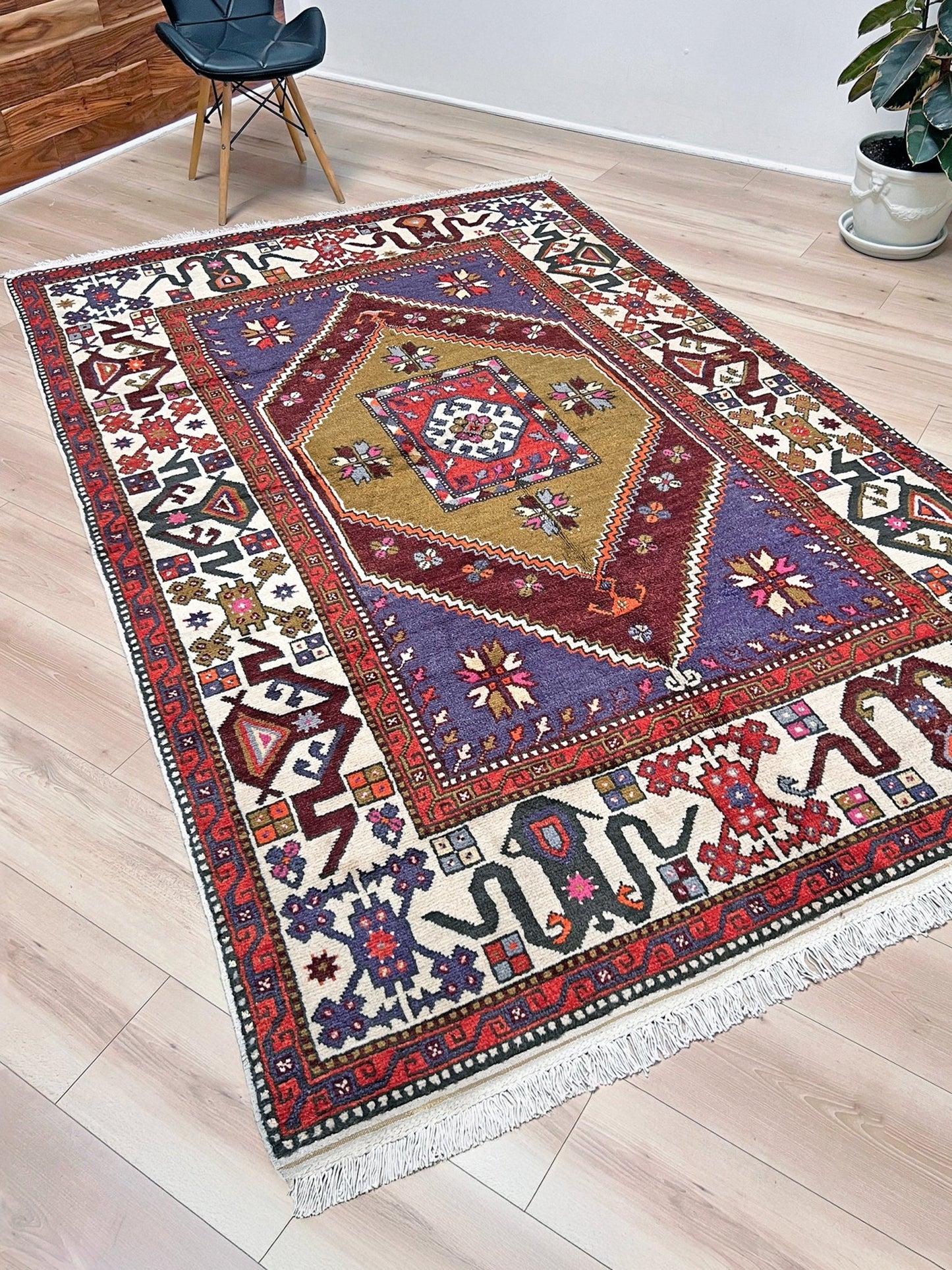 Yuntdag Vintage Turkish Cloudband rug with a golden olive center and bold geometric medallion, surrounded by plum, burgundy, periwinkle, and ivory tribal motifs. Handmade Colorful Vibrant Anatolian wool rug, 6x9 , perfect for living rooms or bedrooms. From Indigo Rugs, Burlingame — San Francisco Bay Area.