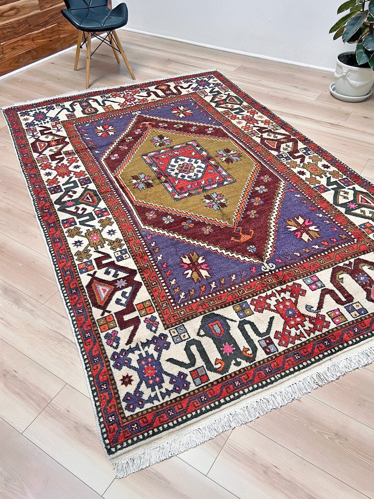 Yuntdag Vintage Turkish Cloudband rug with a golden olive center and bold geometric medallion, surrounded by plum, burgundy, periwinkle, and ivory tribal motifs. Handmade Colorful Vibrant Anatolian wool rug, 6x9 , perfect for living rooms or bedrooms. From Indigo Rugs, Burlingame — San Francisco Bay Area.