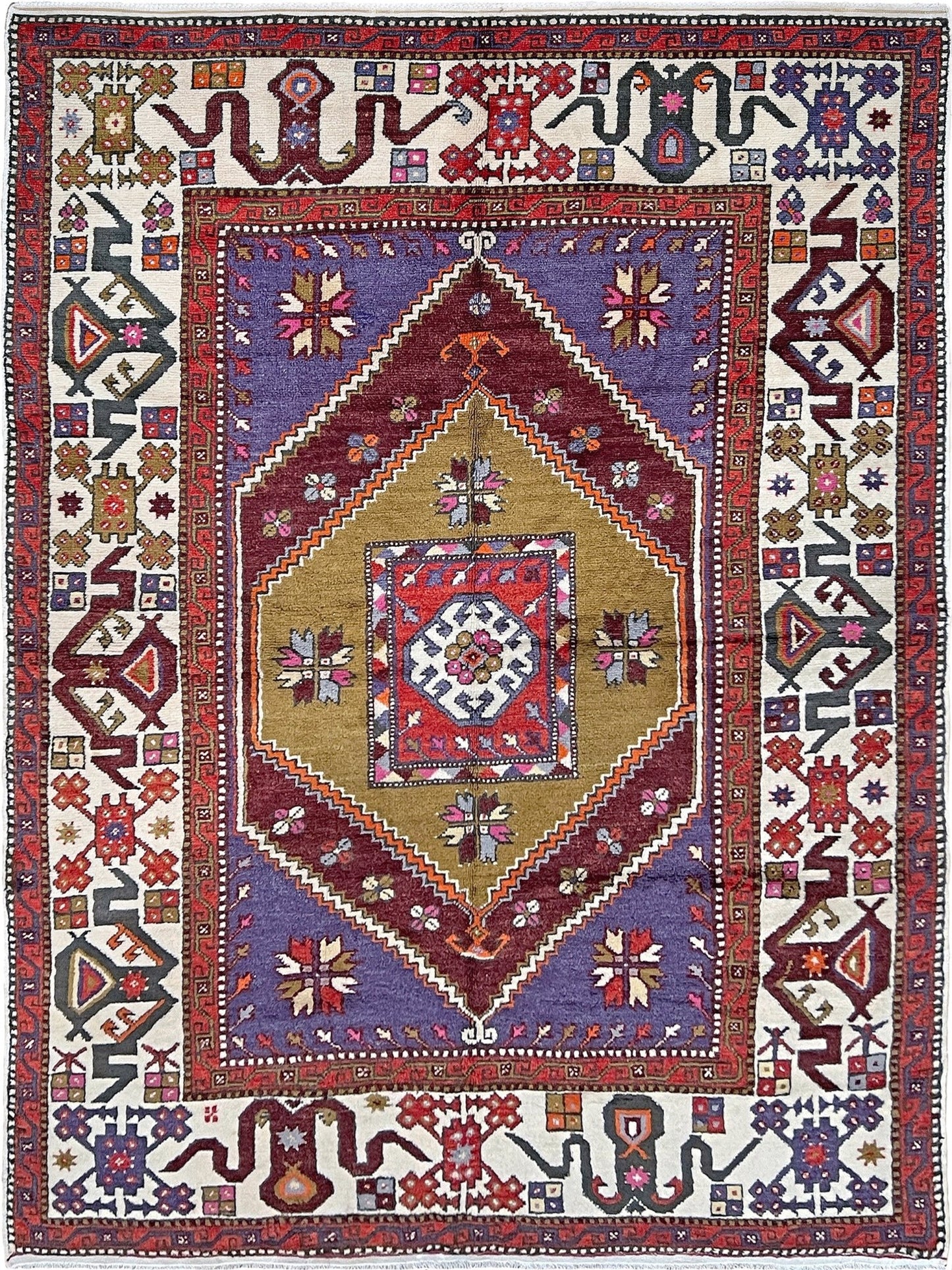 Yuntdag Vintage Turkish Cloudband rug with a golden olive center and bold geometric medallion, surrounded by plum, burgundy, periwinkle, and ivory tribal motifs. Handmade Colorful Vibrant Anatolian wool rug, 6x9 , perfect for living rooms or bedrooms. From Indigo Rugs, Burlingame — San Francisco Bay Area.