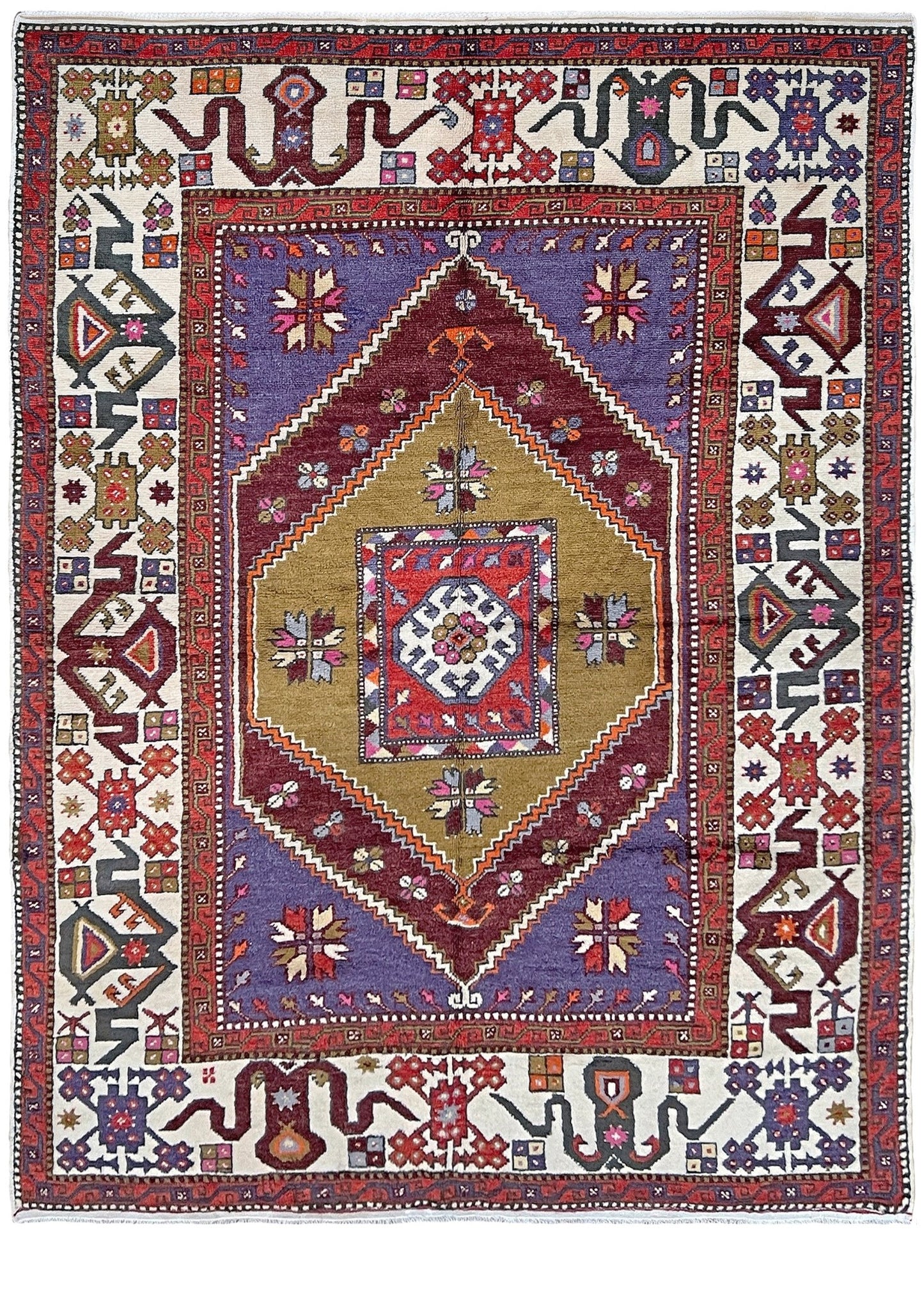Yuntdag Vintage Turkish Cloudband rug with a golden olive center and bold geometric medallion, surrounded by plum, burgundy, periwinkle, and ivory tribal motifs. Handmade Colorful Vibrant Anatolian wool rug, 6x9 , perfect for living rooms or bedrooms. From Indigo Rugs, Burlingame — San Francisco Bay Area.