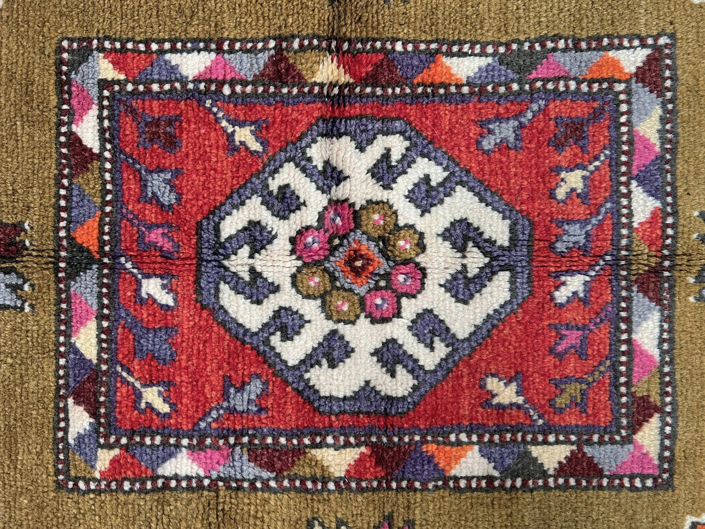 Vintage Turkish Cloudband rug with a golden olive center and bold geometric medallion, surrounded by plum, burgundy, periwinkle, and ivory tribal motifs. Handmade Colorful Vibrant Anatolian wool rug, 6x9 , perfect for living rooms or bedrooms. From Indigo Rugs, Burlingame — San Francisco Bay Area.