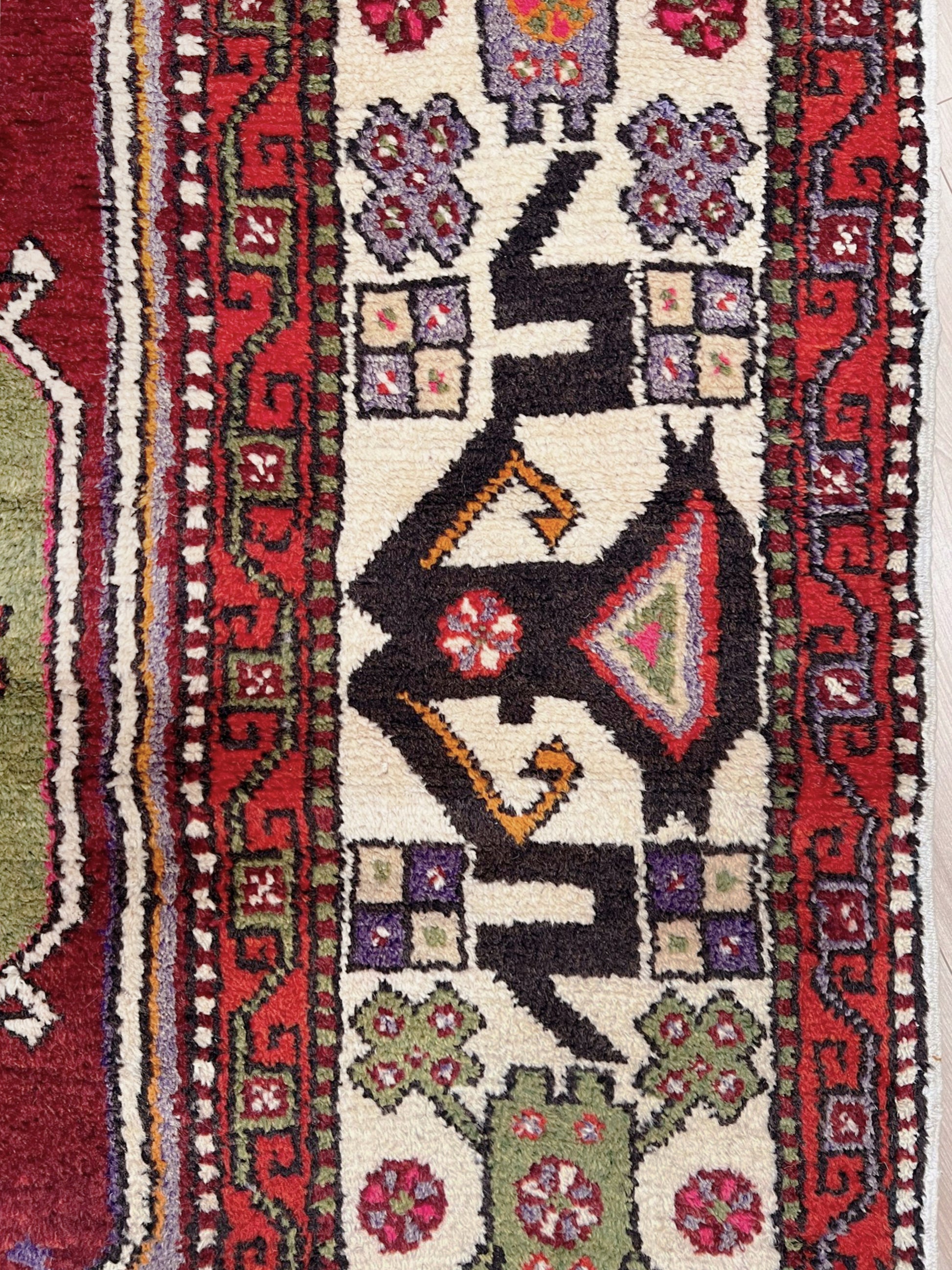 6x9 handmade Turkish vintage rug with geometric medallion, tribal motifs, and lavender, red, and sage green tones — shown in living room at Indigo Rugs, Burlingame — San Francisco Bay Area with free shipping