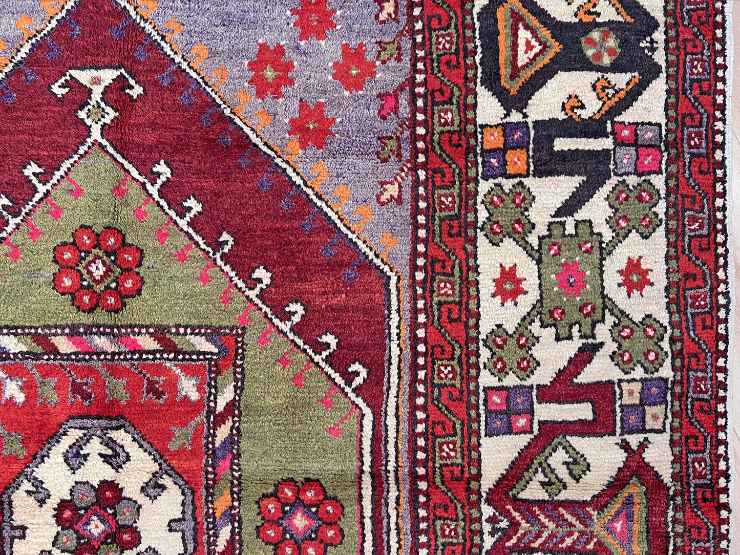 6x9 handmade Turkish vintage rug with geometric medallion, tribal motifs, and lavender, red, and sage green tones — shown in living room at Indigo Rugs, Burlingame — San Francisco Bay Area with free shipping