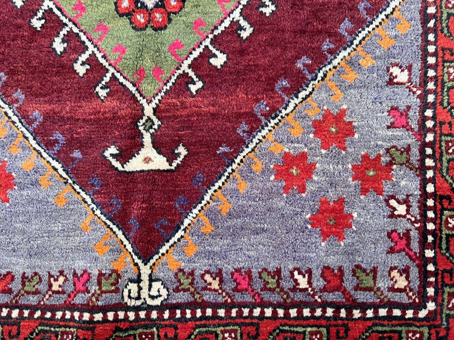 6x9 handmade Turkish vintage rug with geometric medallion, tribal motifs, and lavender, red, and sage green tones — shown in living room at Indigo Rugs, Burlingame — San Francisco Bay Area with free shipping
