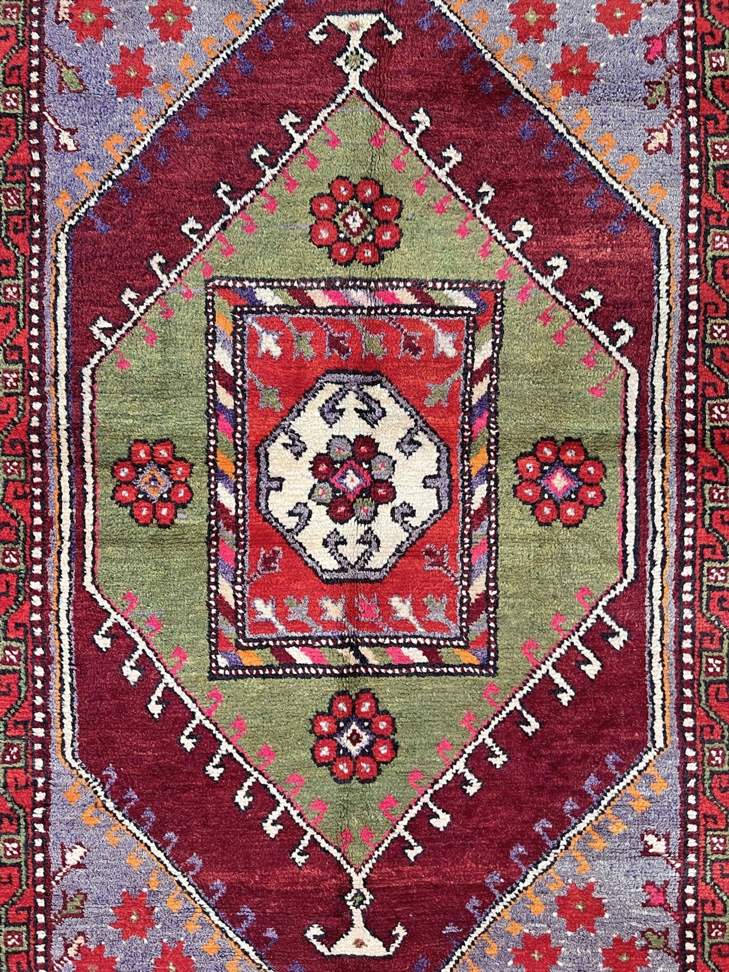6x9 handmade Turkish vintage rug with geometric medallion, tribal motifs, and lavender, red, and sage green tones — shown in living room at Indigo Rugs, Burlingame — San Francisco Bay Area with free shipping