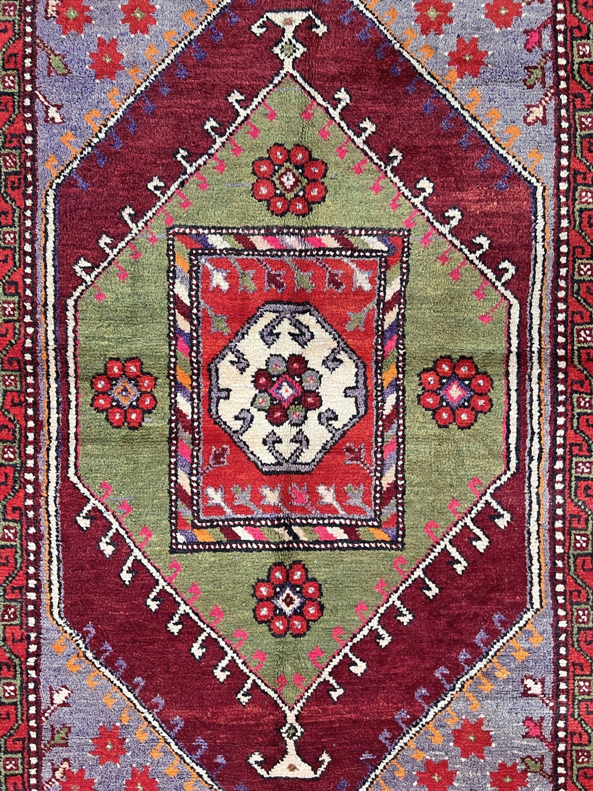 6x9 handmade Turkish vintage rug with geometric medallion, tribal motifs, and lavender, red, and sage green tones — shown in living room at Indigo Rugs, Burlingame — San Francisco Bay Area with free shipping