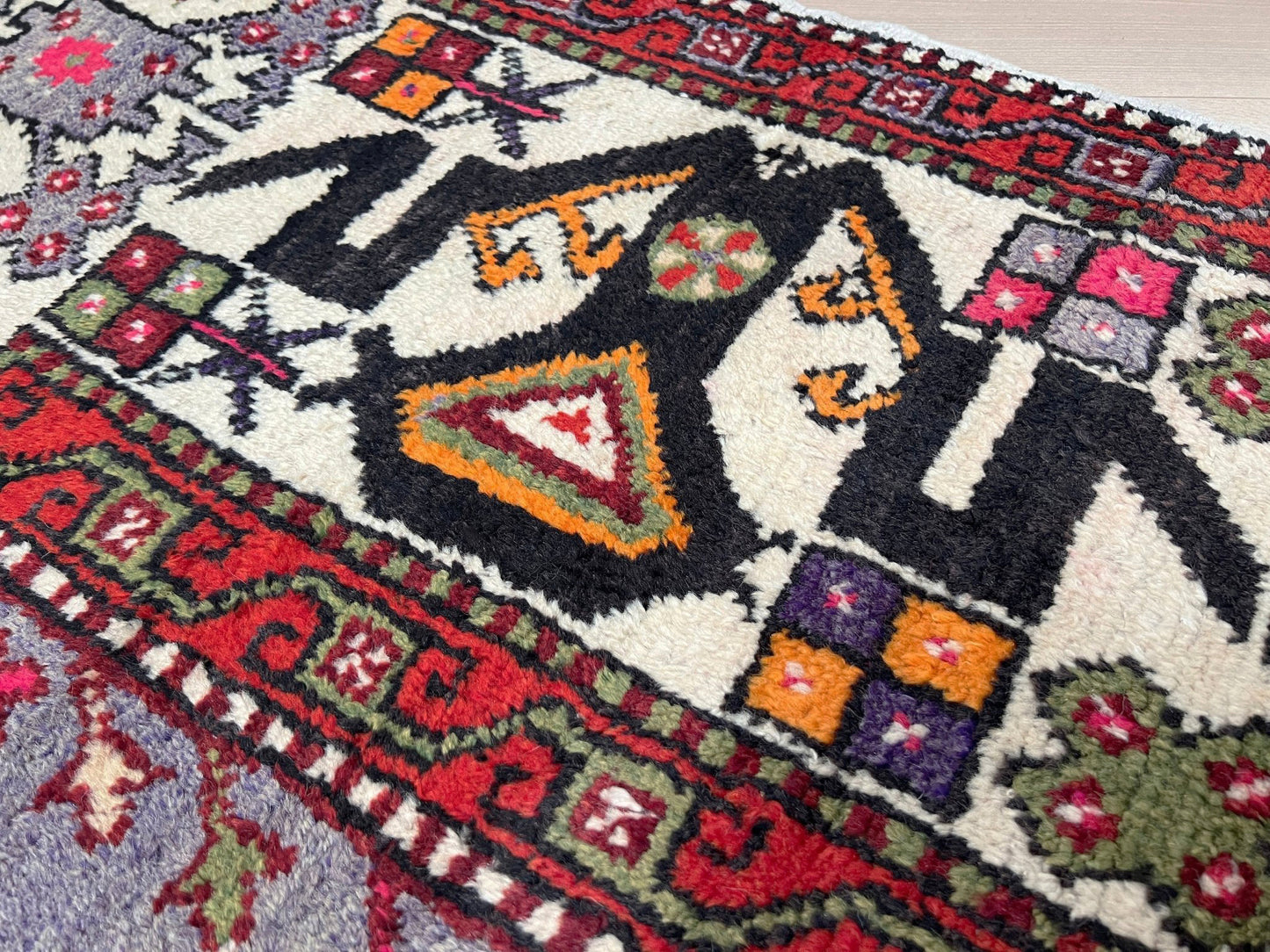 6x9 handmade Turkish vintage rug with geometric medallion, tribal motifs, and lavender, red, and sage green tones — shown in living room at Indigo Rugs, Burlingame — San Francisco Bay Area with free shipping