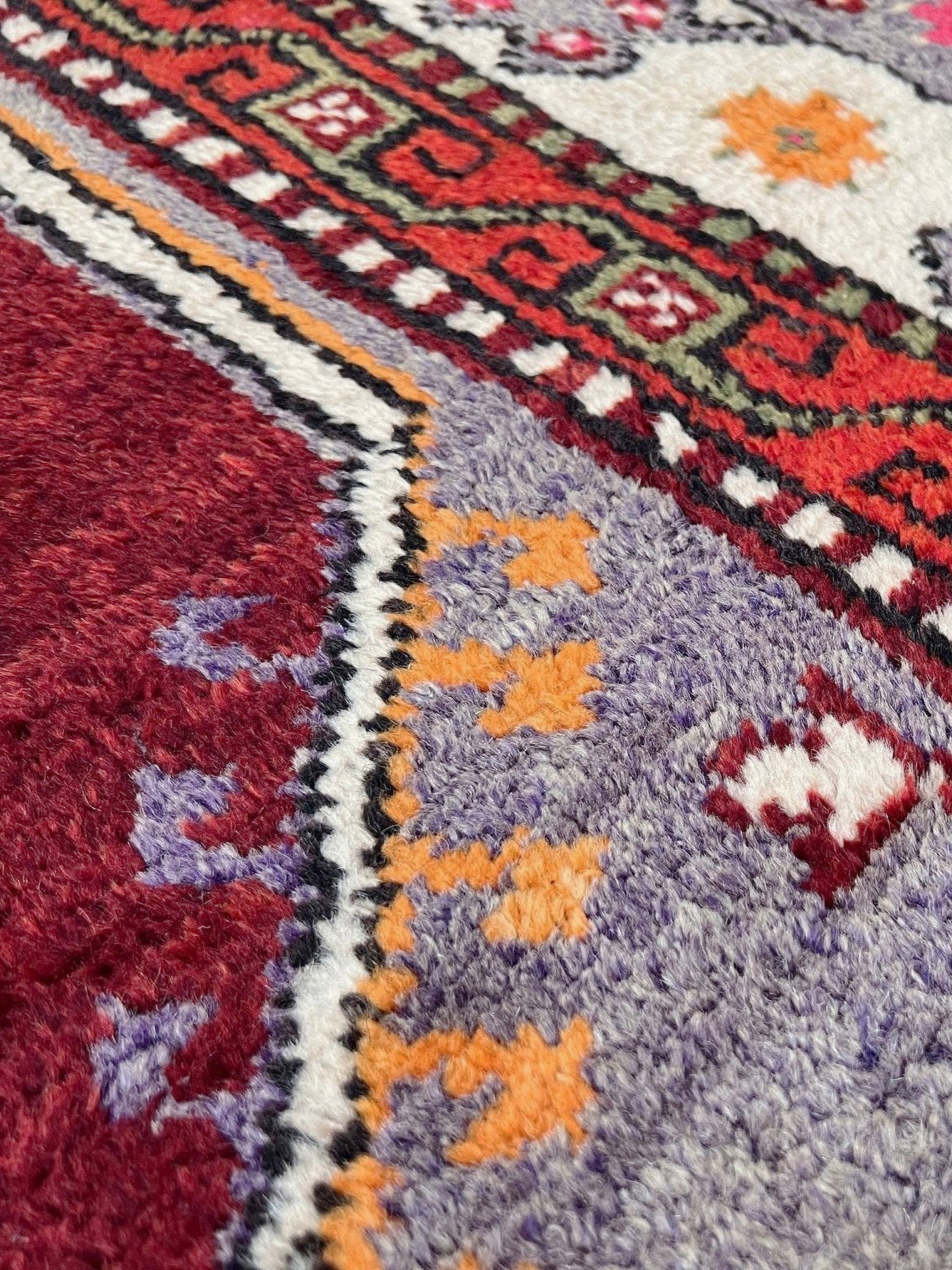 6x9 handmade Turkish vintage rug with geometric medallion, tribal motifs, and lavender, red, and sage green tones — shown in living room at Indigo Rugs, Burlingame — San Francisco Bay Area with free shipping