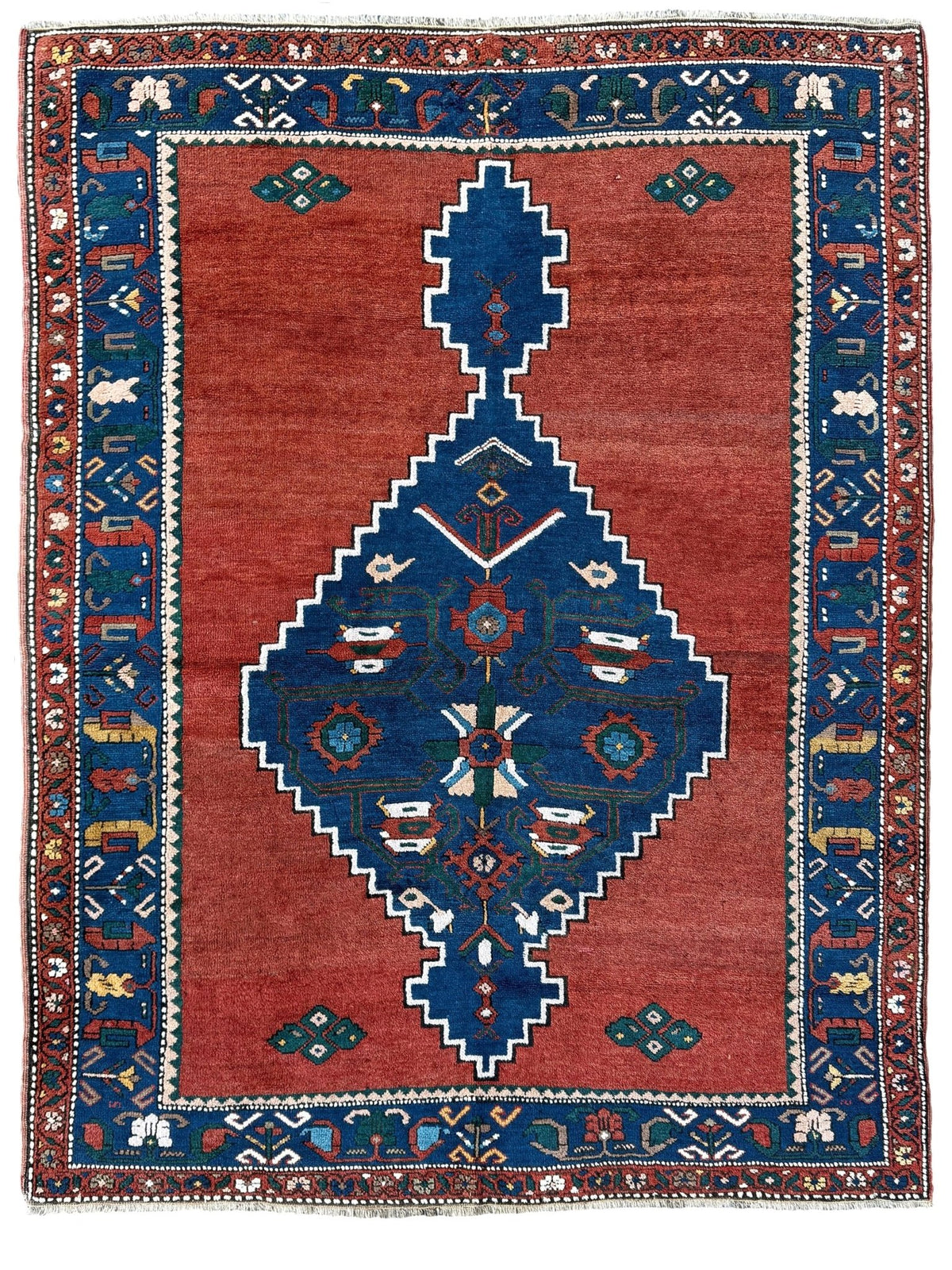 5x7 Vintage Caucasian rug with a terracotta red field and a bold midnight blue geometric medallion. From  the best rug shop san francisco bay area Burlingame CA