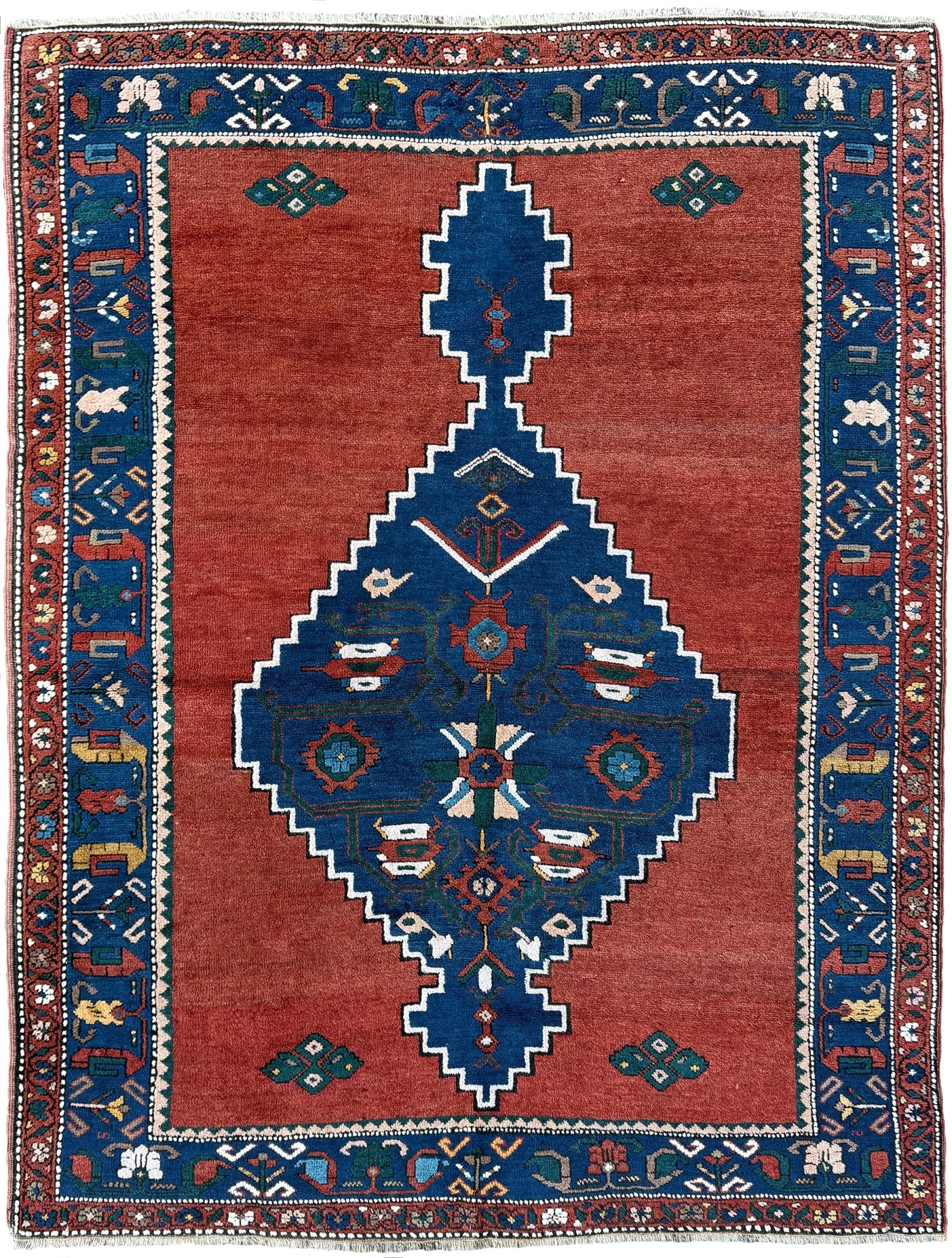 5x7 Vintage Caucasian scatter rug with a terracotta field and a bold midnight blue geometric medallion, accented with melon, ivory, and baby blue motifs. From  the best rug shop san francisco bay area Burlingame CA free shiping