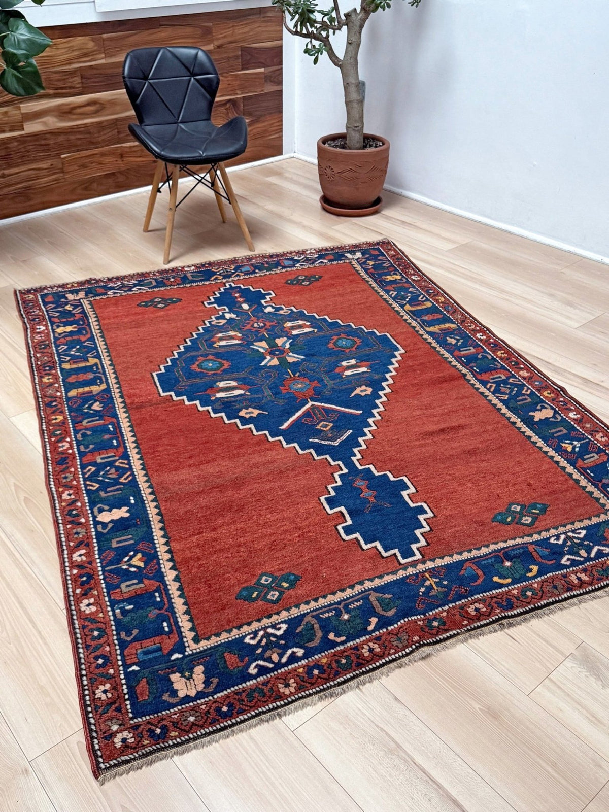 5x7 Vintage Caucasian rug with a terracotta red field and a bold midnight blue geometric medallion. From  the best rug shop san francisco bay area Burlingame CA