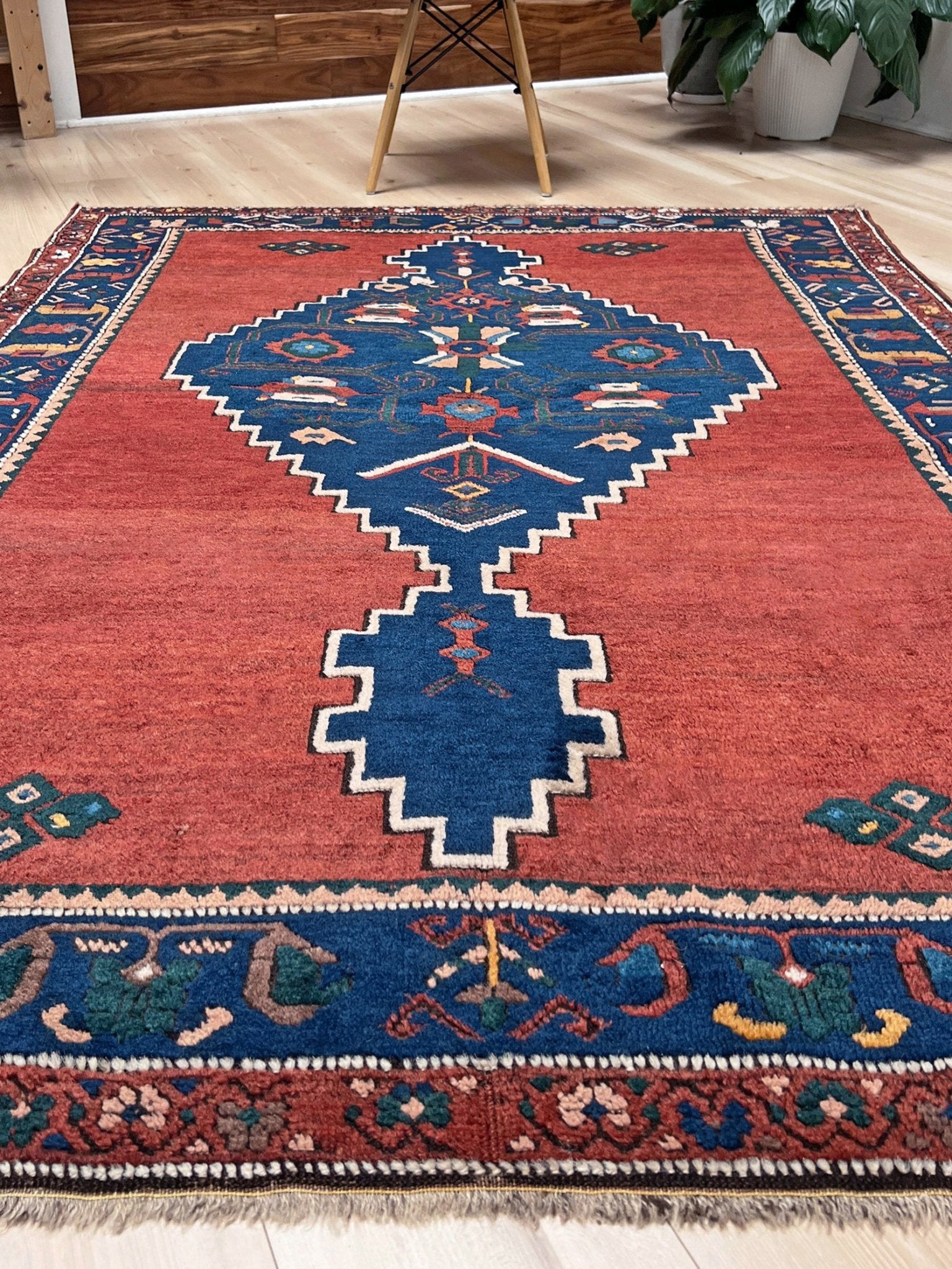 5x7 Vintage Caucasian scatter rug with a terracotta field and a bold midnight blue geometric medallion, accented with melon, ivory, and baby blue motifs. From  the best rug shop san francisco bay area Burlingame CA free shiping